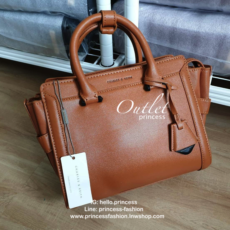 CHARLES & KEITH กระเป๋าถือ/สะพายข้าง ขนาดกลาง ด้านหน้าปั๊มโลโก้แบรนด์ ด้านหน้าเป็นหนังเรียบตัดกับด้านข้างเป็นหนังคาร์เวียร์ออกแบบมาให้เรียบหรู ด้านหลังมีซิป 1 ช่อง หูกระเป๋าสามารถพับลงได้ ส่วนด้านในกว้างมากค่ะ ออกแบบมาให้ใส่ของได้จุใจแบบไม่มีช่องแบ่ง มีช่