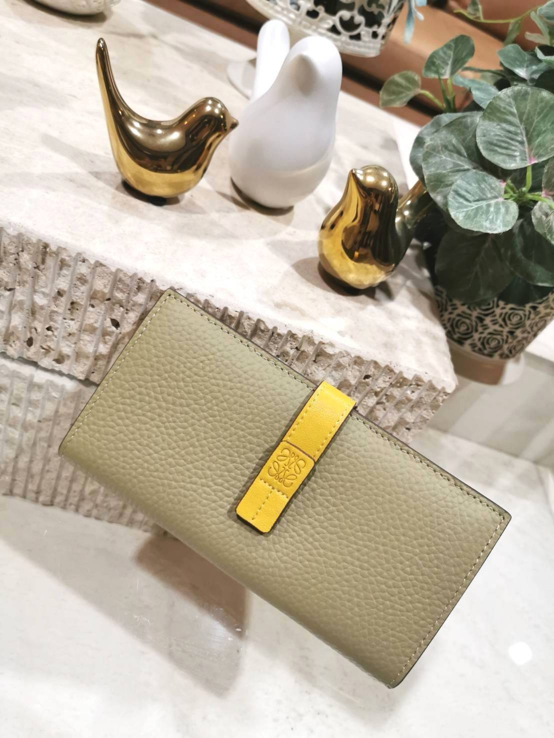 LOEWE LONG WALLET BAG วัสดุหนังแท้เทคเจอร์สวยอยู่ทรงปั้มโลโก้แบรนด์ด้านหน้าเปิดปิดด้วยกระดุม ภายในมีช่องใส่ธนบัตรหลายช่อง ช่องหลักสามารถใส่มือถือได้ มีช่องซิปใส่เหรียญ ช่องใส่ธนบัตรใส่แบงก์พันได้ สวยน่าใช้ พร้อมส่งที่ไทยสุดคุ้มห้ามพลาด!