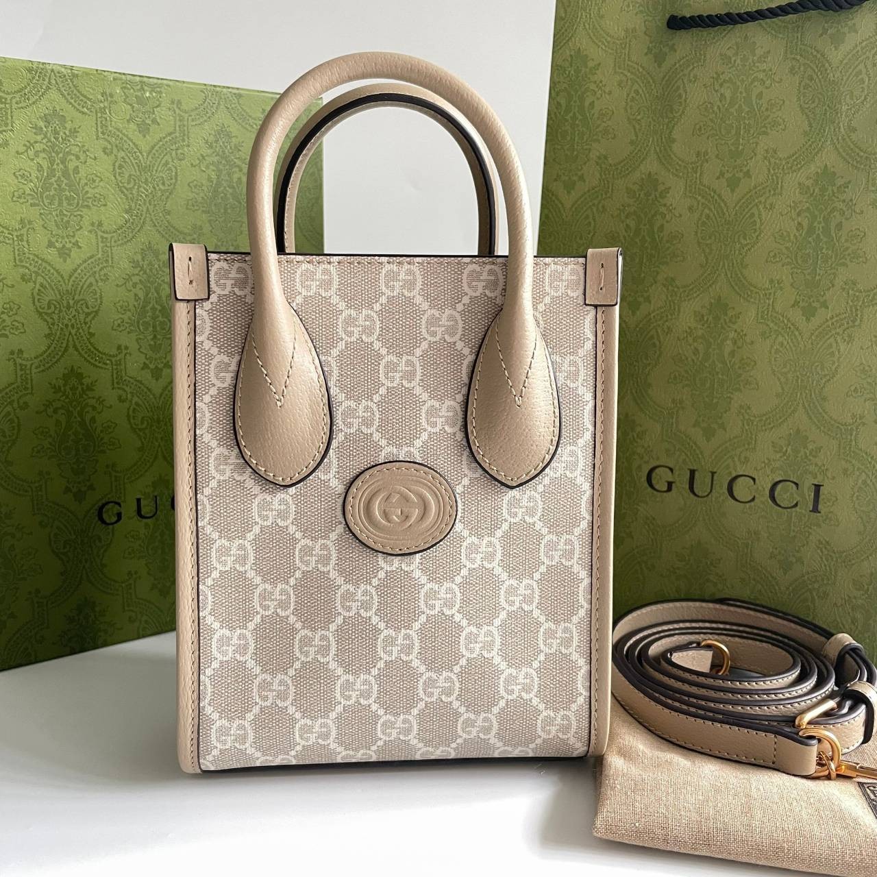 หนังแท้ GUCCI Mini tote bag with Interlocking G พร้อมส่งที่ไทย Beige and white GG Supreme canvas เกรดออริจินอล ภาพสินค้าถ่ายจากงานขายจริง ใช้งานต่างประเทศได้ The mini tote bag is complete with an oatmeal leather trim and an Interlocking G tag.