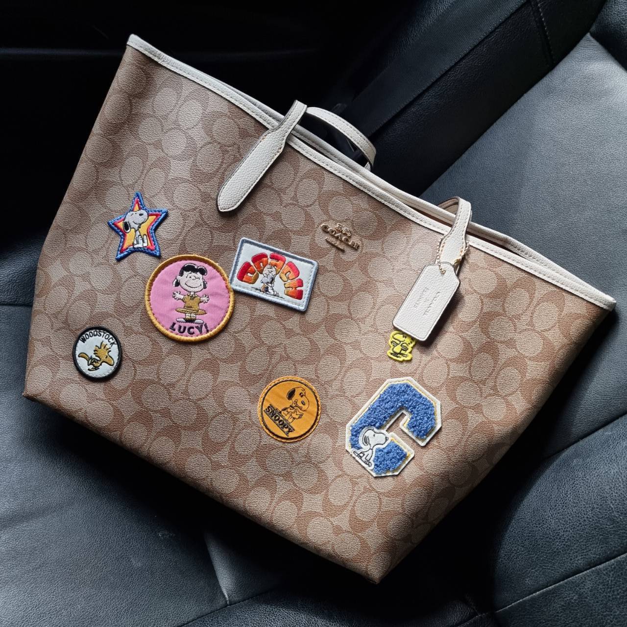 COACH C4292 COACHxPEANUTS CITY TOTE IN SIGNATURE CANVAS WITH VARSITY PATCHES กระเป๋าทรงโท้ทใบใหญ่ กับคอลเลคชั่นคอลแลบใหม่ล่าสุด น่ารักด้วยเหล่าผองเพื่อนสนู้ปพี สวยโดดเด่นมากๆ ใบนี้ใส่ของได้ของครบครัน จุได้แบบไม่ต้องกลัวเต็ม!! วัสดุหนังแคนวาสคุณภาพดี ปากกร