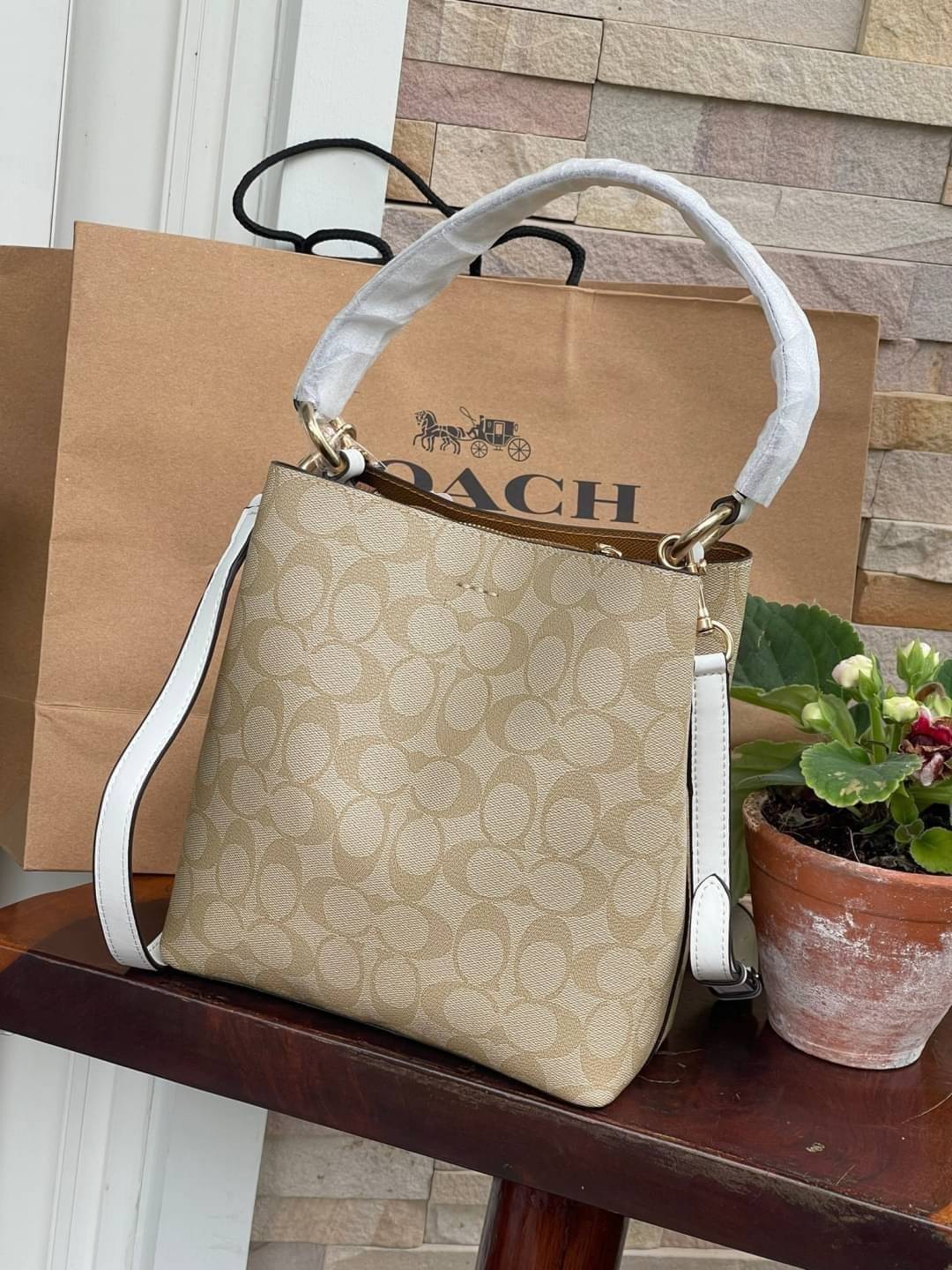 COACH SMALL TOWN BUCKET BAG IN SIGNATURE สำหรับสาวแฟชั่นที่ชอบรายละเอียดชิคๆ ดีไซน์สุดเก๋ แนะนำเลยสำหรับกระเป๋าทรงบักเก็ตใบนี้ เชื่อว่าสาว ๆ หลายคนชื่นชอบ เป็นไอเทมที่สามารถแมทช์ได้กับเสื้อหลากหลายสไตล์ บรรจุของได้เยอะโดยที่กระเป๋าไม่เสียทรง แบ่งช่องใช้งา