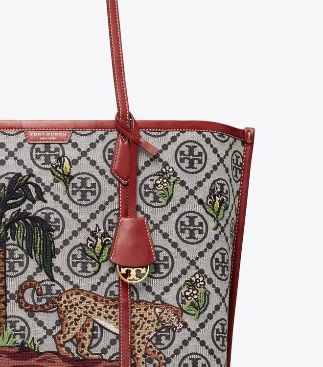 Tory Perry Embroidered T Monogram Triple Compartment Tote Bag เป็นแพทเทิร์นที่ได้รับแรงบันดาลใจจากการควิลท์สไตล์เพนซิลเวเนียดัตซ์ดั้งเดิมและเฉลิมฉลองโลโก้อันเป็นสัญลักษณ์ของแบรนด์ วัสดุผ้าแจ็คการ์ดแบบทอหนัง อะไหล่ทอง โดดเด่นด้วยลายเสือชีร์ต้าร์ งานเย็บปัก