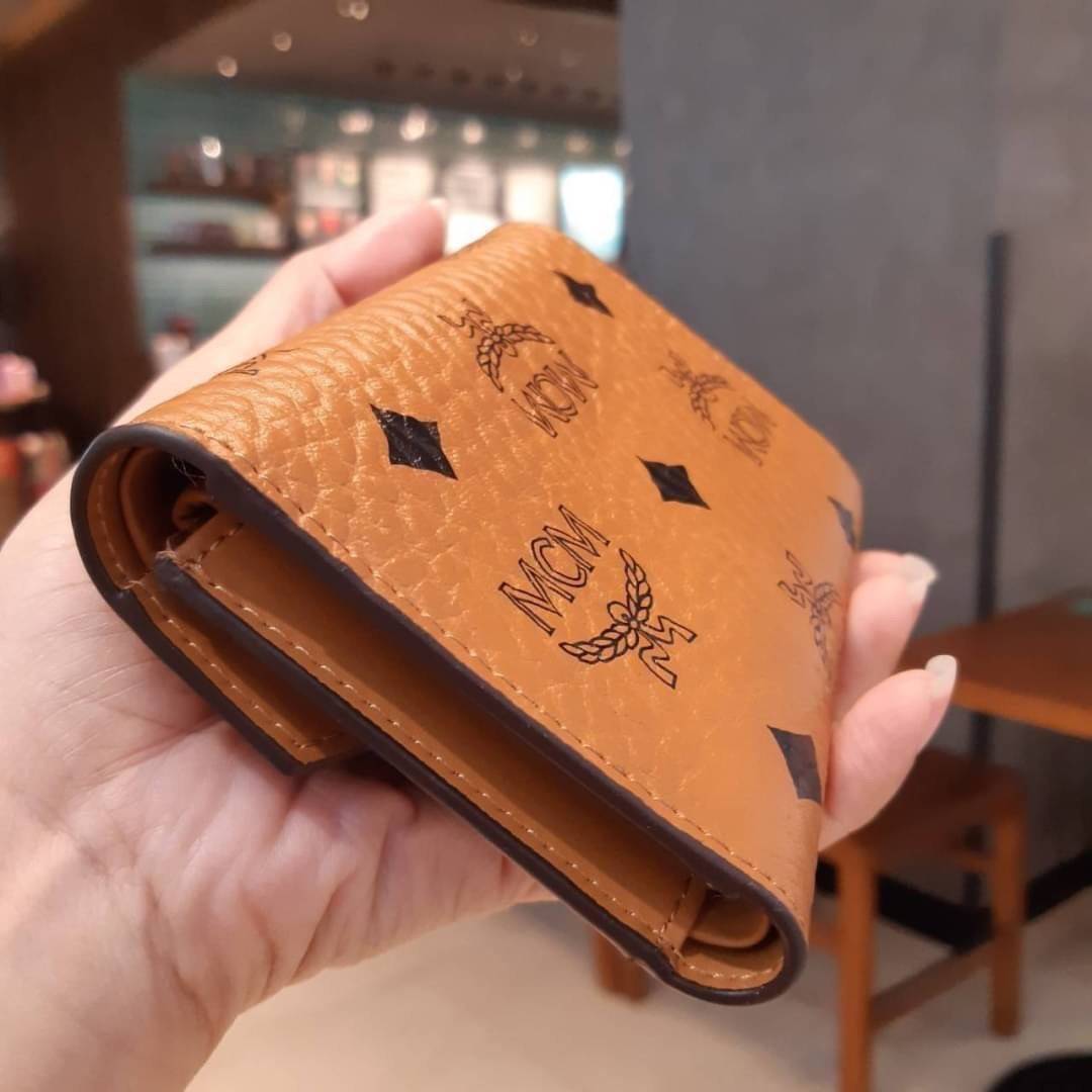 M.C.M PATRICIA THREE-FOLD WALLET IN VISETOS กระเป๋าสตางค์ใบเล็ก รุ่นฝาพับ unisex ใช้ได้ทั้งหนุ่มๆและสาวๆน้า ใช้งานง่าย ด้วยกระดุมโลโก้ พกพาง่าย วัสดุหนังแคนวาสคุณภาพดี ภายในเป็นหนังแท้ นิ่ม สวย ใส่บัตรได้เยอะ ใส่ธนบัตรได้ทุกชนิด ในช่องมีที่ใส่บัตรพิเศษภาย