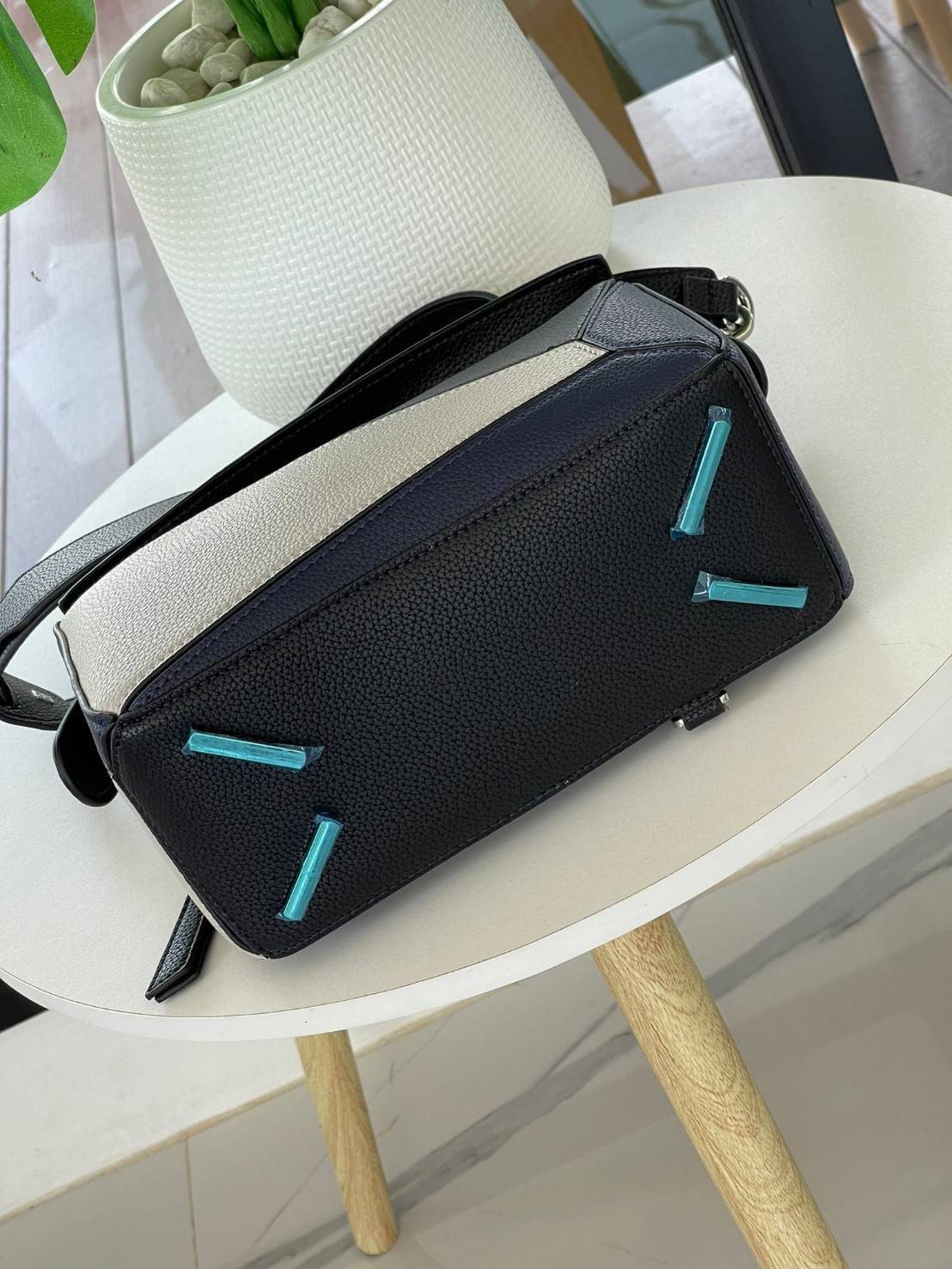 Loewe Puzzle Bag In Classic กระเป๋าทรง Puzzle นี้ออกแบบโดย Jonathan Anderson โดยได้รับแรงบันดาลใจในการออกแบบมาจากรูปทรงของลูกรักบี้ ดังนั้น จึงจะเห็นได้ว่าการตัดเย็บและรูปทรงของกระเป๋านั้นคล้ายคลึงกับลูกรักบี้ รูปทรงดูมินิมอลไม่ทิ้งคอนเซ็ปต์ของแบรนด์ สามา