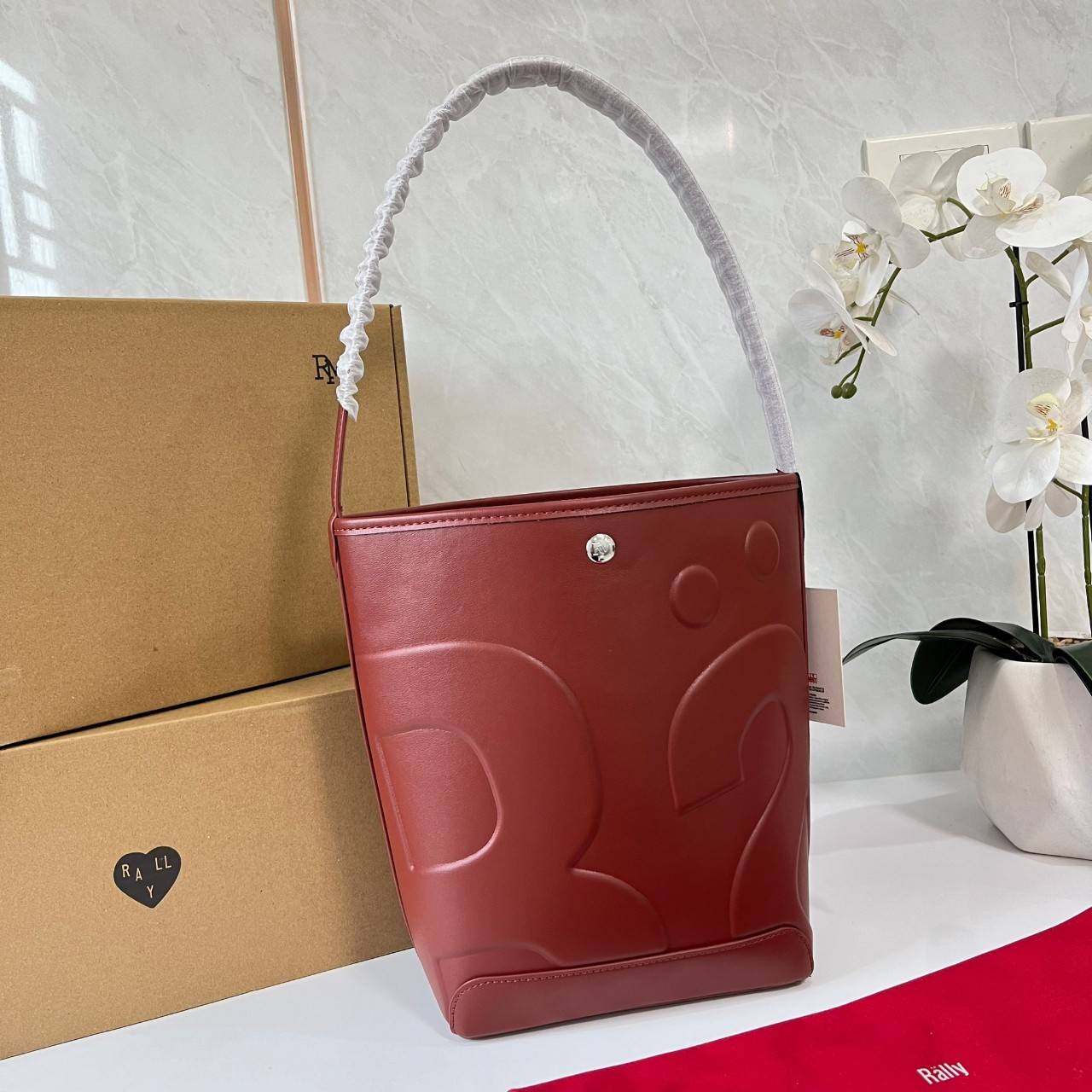 Rally The Bag Whisper กระเป๋าทรงบัคเก็ตงานหนังรุ่นใหม่ ฮอทติดลมบน มาแรงสะพายกันทั่วบ้านทั่วเมือง สายแบกสายขนห้ามพลาดจุของได้เยอะ รุ่นหนังผิวสัมผัสนิ่มมือ ทนทานและจุสิ่งของได้ครบครัน โดดเด่นด้วยโลโก้ตัวนูน