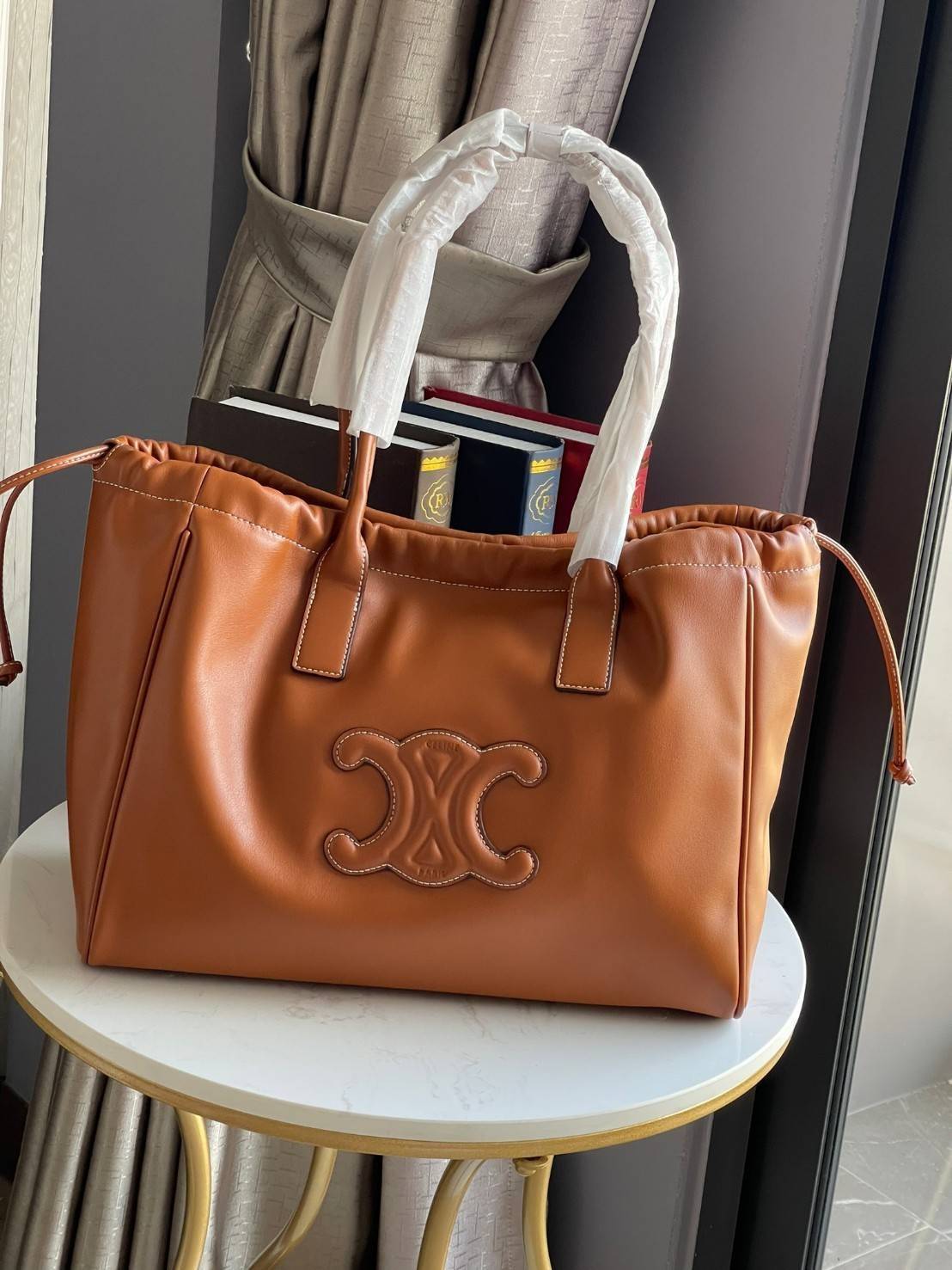 Celine cabas drawstring cuir triomphe in Smooth Calfskin / celine shopping bag เป็นกระเป๋าที่ดีไซน์คลาสสิก เรียบหรู ไม่ตกยุค โดดเด่นเพราะมีโลโก้อยู่ตรงกลาง ออกแบบมาให้ใส่ของใช้ในชีวิตประจำวัน ซึ่งคุณสามารถใช้เป็นกระเป๋าถือหรือสะพายไหล่ก็ล้วนเก๋และมีความคล