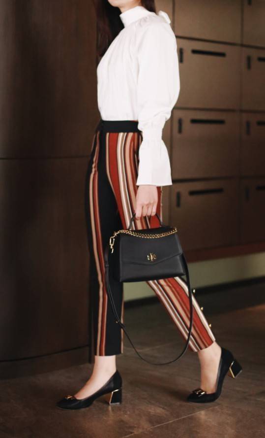 TORY BURCH KIRA MIXED-MATERIALS TOP-HANDLE SATCHEL กระเป๋าสะพายข้าง วัสดุหนังแกะสังเคราะห์ อะไหล่ทอง ด้านหน้าประดับโลโก้แบรนด์ ตกแต่งสายโซ่ห้อยสีทอง (สามารถถอดออกได้) เปิด-ปิดด้วยตัวล็อคหมุน ภายในโล่งกว้าง ซับในบุผ้าลายแบรนด์ แบ่งออกเป็น 3 ช่องใหญ่ พร้อมช