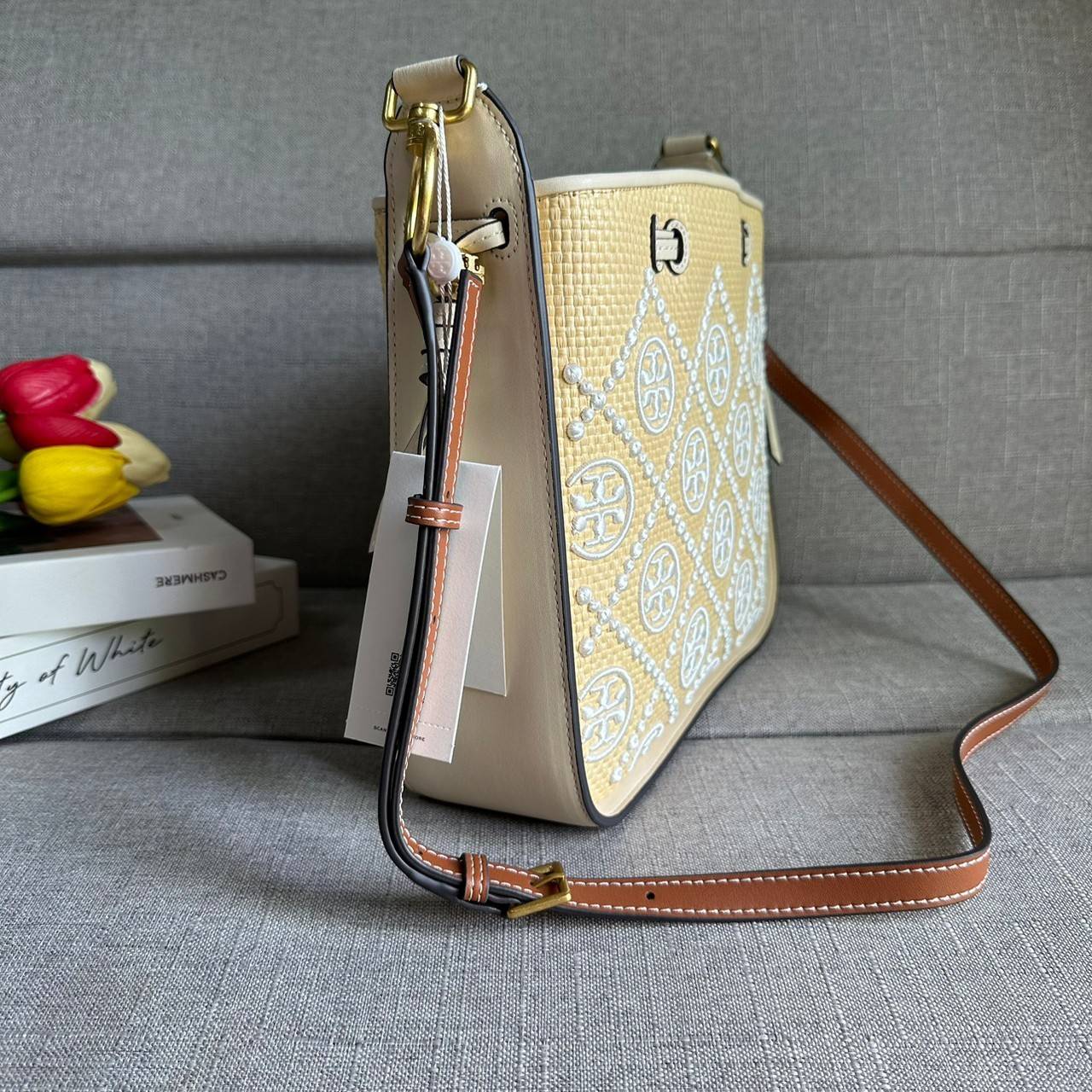 TORY BURCH T Monogram Straw Bell Bag กระเป๋าสะพายข้างรุ่นคลาสสิกที่ได้แรงบันดาลใจจากการควิลท์แบบดั้งเดิมของเพนซิลเวเนีย คอลเลกชันบ่งบอกถึงความมีสไตล์เหนือกาลเวลา รูปทรงเรียวโดดเด่น ปักทอลายแบรนด์อย่างสวยงาม เปิด ปิดด้วยเชือกรูด ด้านในช่องโล่งกว้าง ซับในผ้