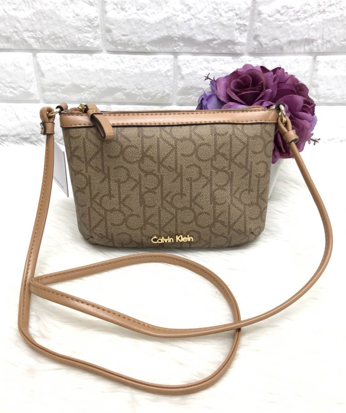 CALVIN KIEIN MINI CROSSBODY BAG กระเป๋าสะพาย size mini น่ารัก วัสดุหนังลายแบรนด์รอบใบ ด้านหน้าประกับ l0go brand อะไหล่ทอง เปิดปิดกระเป๋าแบบซิป ภายในโล่ง ใส่ธนบัตร, bookbank, มือถือได้ทุกรุ่น สายสะพาย เป็นหนังนิ่มสะพายสบาย ใบนี้ classic ตลอดกาลค่ะ