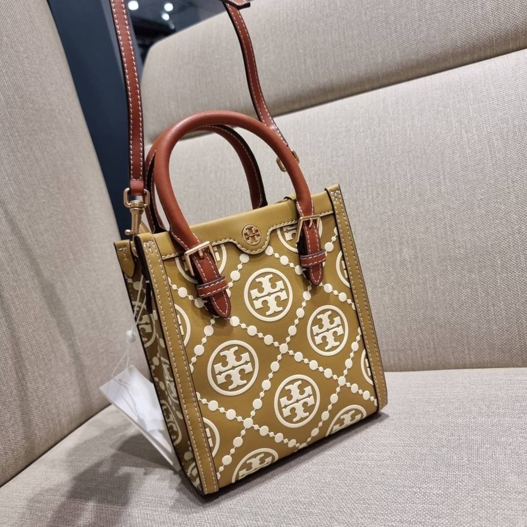 TORY BURCH T MONOGRAM EMBOSSED MINI TOTE สุดหรูกับกระเป๋าสะพายทรงโท้ท ไซส์มินิ ที่สร้างความหรูหราให้ตัวกระเป๋าด้วยดีเทลลายนูน แต่งแต้มลวดลายเอกลักษณ์ สีลูกคุณมากๆ!! วัสดุหนังแท้ ผิวสัมผัสดี ปากกระเป๋ามีแถบแม่เหล็กกันของหล่นได้ ภายในโล่ง ใส่ของจำเป็นได้ โท