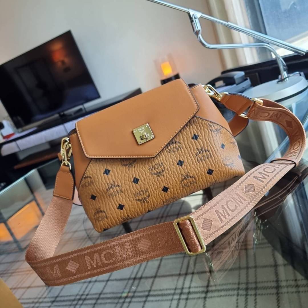 M.C.M ESSENTIAL CROSSBODY IN VISETOS กระเป๋าสะพายข้าง สวยอยู่ทรง ดีไซน์ไม่ซ้ำใคร มาพร้อมสายสะพายถึง 2 แบบ ปรับเปลี่ยนใช้ได้ไม่มีเบื่อ วัสดุหนังแคนวาสสลับหนังแท้ เปิด-ปิดกระเป๋าด้วยตัวบิดล็อคแน่นหนา ด้านหลังมีช่องเก็บบัตรได้ ภายในโล่งกว้าง แบ่งสัดส่วน เป็น