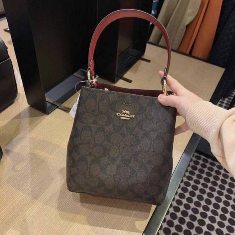 COACH 2312 SMALL TOWN BUCKET BAG IN SIGNATURE CANVAS รุ่นยอดนิยมใบเล็กมาครบสีแล้วจ้า กระเป๋าทรงบัคเก็ต สีผู้ดี๊ผู้ดี ตัวกระเป๋าดีไซน์คลาสสิคลายซี ดูโดดเด่น วัสดุหนังแคนวาสเคลือบลาย สวยคมทุกมุมจริงๆ!! เปิด-ปิดด้วยกระดุมแม่เหล็กทั้ง 2 ฝั่ง ภายในเป็นช่องโล่ง