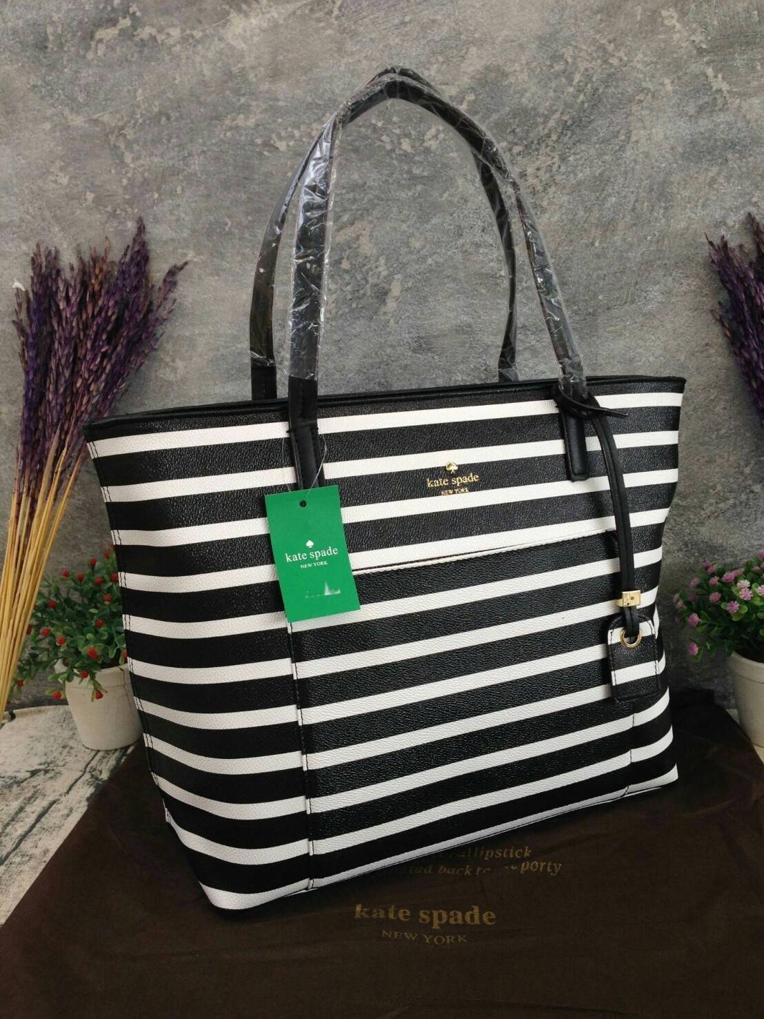 KATE SPADE HYDE LANE STRIPED RILEY LEATHER TOTE BAG กระเป๋าสะพายทรง Tote Bag หนังสวยอยู่ทรง โดดเด่นที่สีทูโทนลายทางห้อยโลโก้ TAGcที่หูกระเป๋า ด้านหน้าประดับโลโก้ มี1ช่องใส่ของ ภายในมีช่องซิป และช่องใส่มือถือ กว้างและจุ ใส่ ipad notebook เอกสาร A4 กระเป๋าส