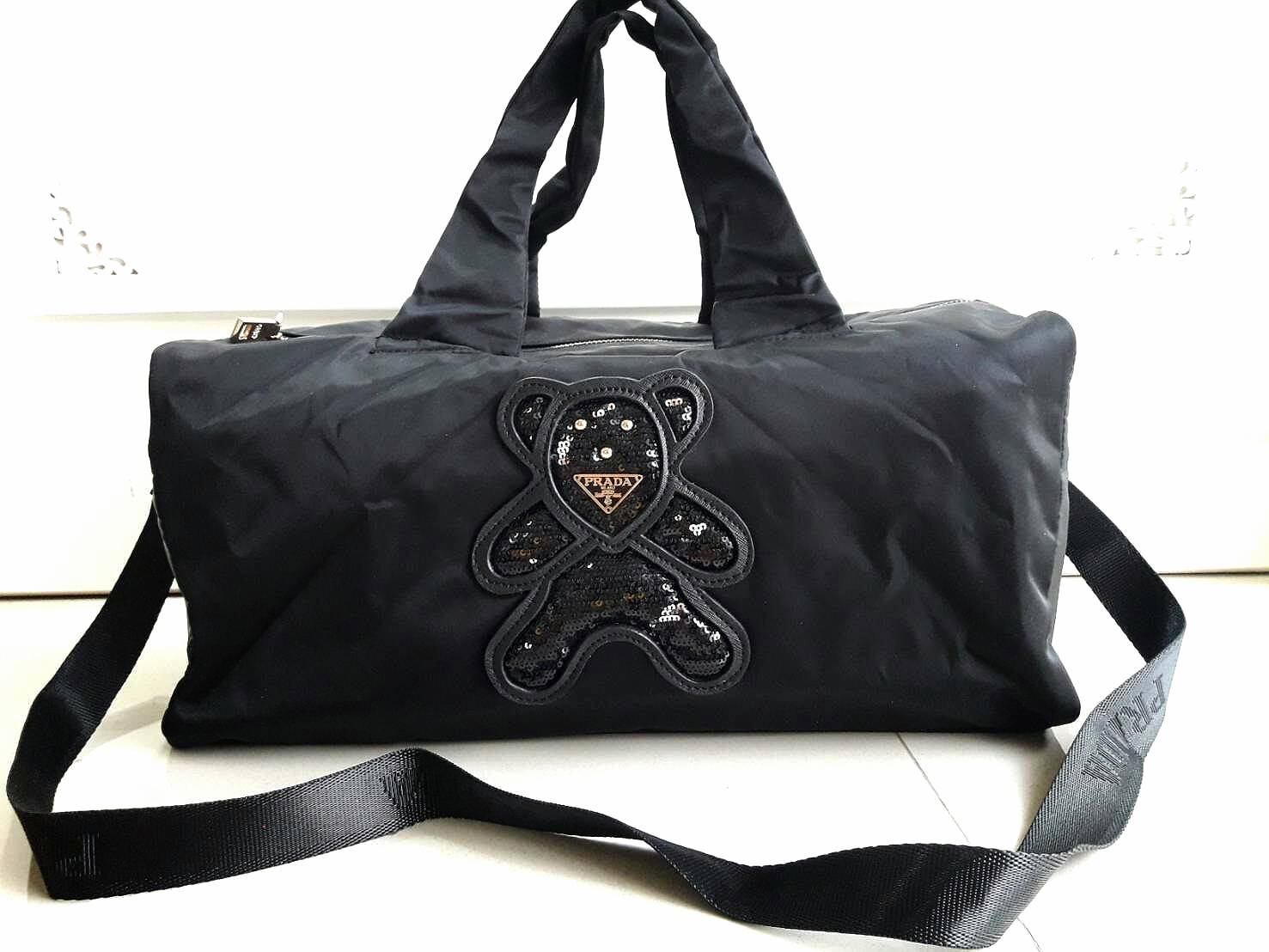 New arrival ! กระเป๋าทรง travel pillow bag จากงานพรีเมี่ยมกิ้ฟท์แบรนด์ PRADA ค่า เป็น กระเป๋าผ้า nylon ทั้งใบเลย น้ำหนักเบา สะพายสบายไหล่คะ ด้านหน้าปัก logo brand บนหมี ส่วนด้านหลักเป็น logo ชื่อแบรนด์คะ อะไหล่ทองทั้งใบ ด้านในกว้างม้ากกกกกกกบุผ้าปั้มแบรนด