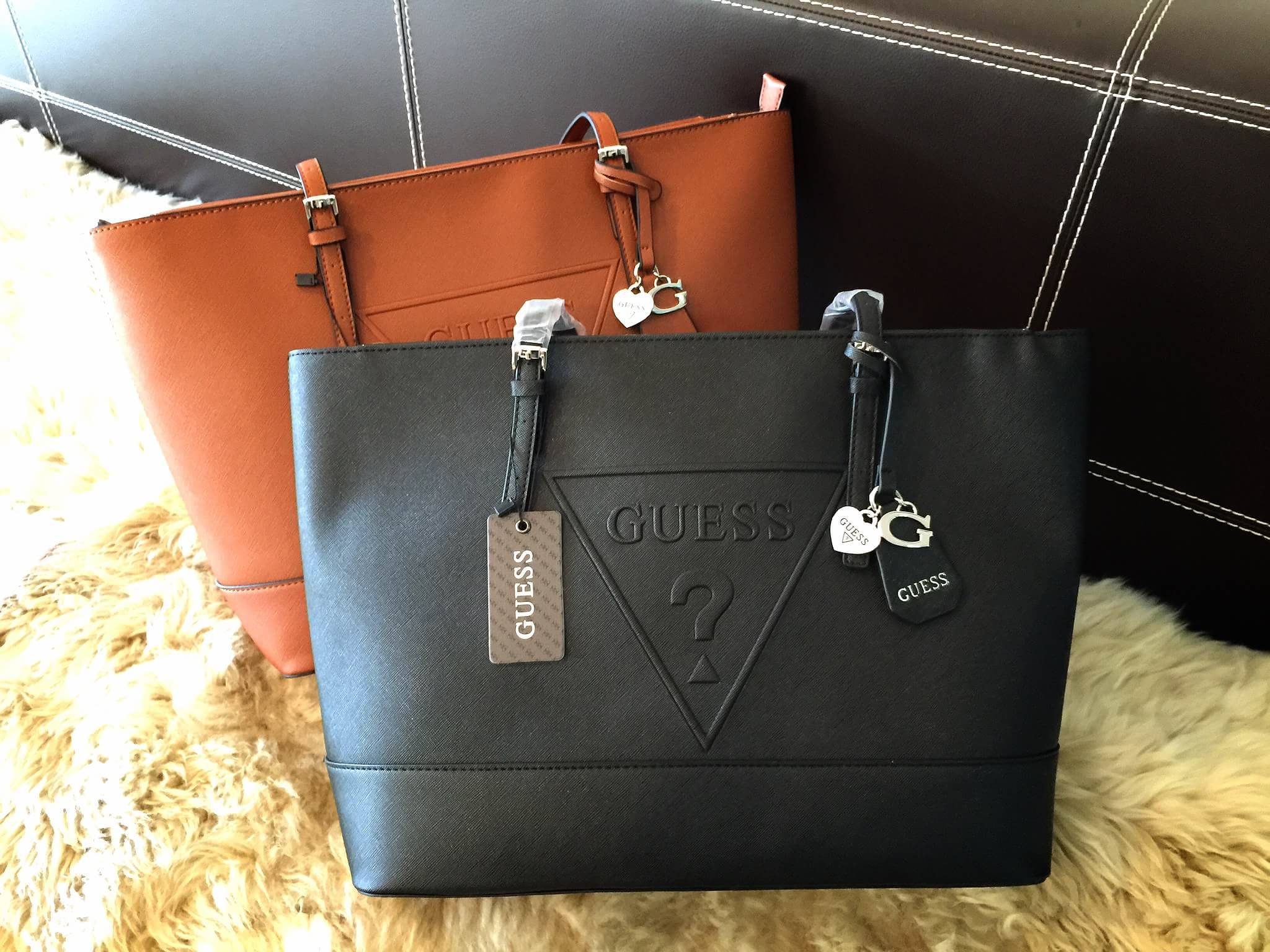 Guess Saffiano Shopping Bag กระเป๋าถือและคล้องบ่าทรงช้อปปิ้งใบใหญ่ หนังSaffiano ใส่เอกสารขนาด A4 ได้ จุของได้เยอะ ด้านหน้าสลักแบรนด์หนังลายนูนพร้อมประดับtagสายหนังถอดออกได้ เปิดปิดด้วยซิปเดียวด้านบน ภายในบุผ้าติดโลโก้ มีช่องเล็กและข่องใส่โทรศัพท์ เรียบง่า