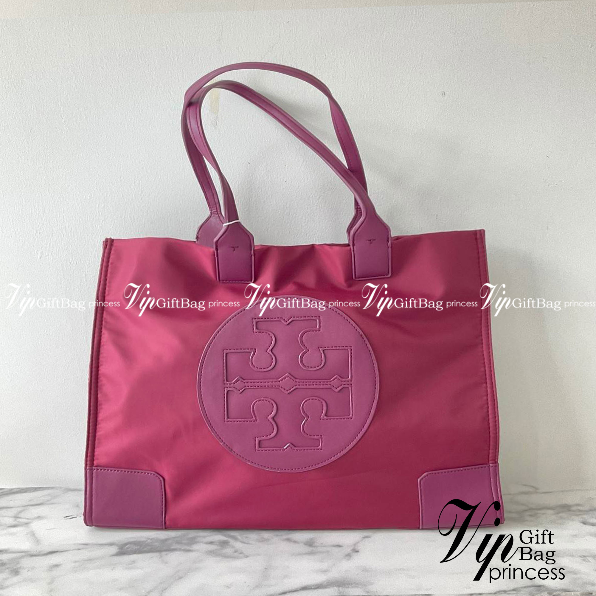 กระเป๋าทรงโท้ทใบใหญ่ TORY BURCH ELLA TOTE BAG วัสดุ NYLON ทั้งใบตัดด้วยหนังสีดำ แต่งโลโก้แบรนด์ด้านหน้า ด้านข้างมีกระดุม สามารถขยายทรงได้ ด้านในเปิดปิดด้วยกระดุมแม่เหล็กฝัง ช่องกว้างหลักหนึ่งช่องและช่องซิปอีกช่อง สามารถใส่แล็ปท็อปได้สบาย ใบใหญ่เว่อวัง ไอเ