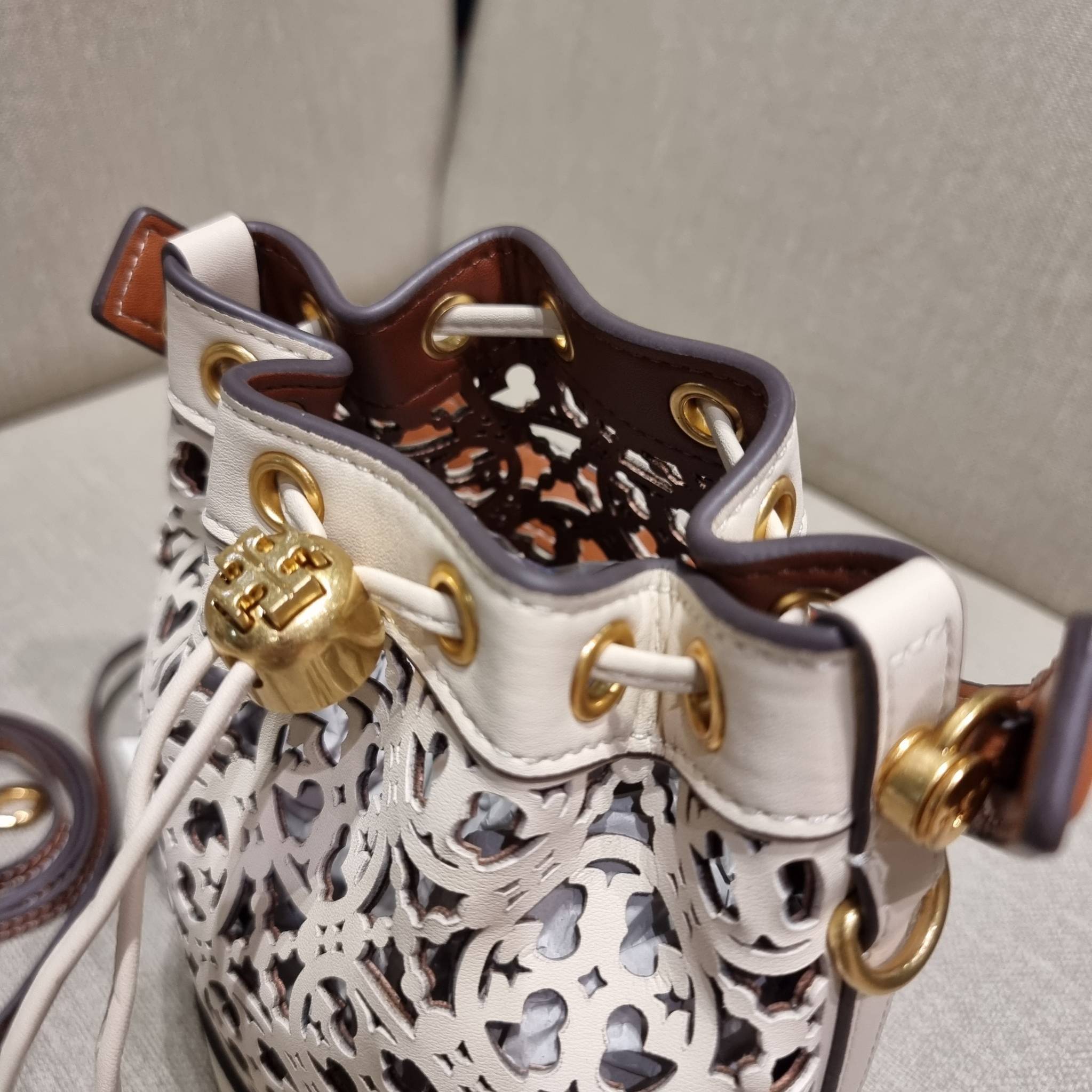 TORY BURCH T MONOGRAM LASER-CUT MINI BUCKET BAG ใจบางที่สุดกับคอลเลคชั่นนี้ กับกระเป๋าสะพายทรงบัคเก็ต ไซส์มินิ รุ่นชูโรงสุดฮิต ที่เพิ่มดีเทลความแพงด้วยการฉลุลวดลายโมโนแกรมรอบใบ ถักทอเป็นเส้นลายสานที่สวยงามมาก งานฝีมือจริงๆ วัสดุหนัง cowhide รูดเปิด-ปิดด้ว