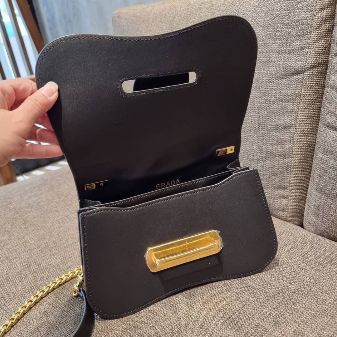PRADA FRAGRANCE SHOULDER BAG WITH GWP ไอเท็มสุดโปรดที่ควรค่าแก่การครอบครองและเก็บสะสม กระเป๋าสะพายไหล่ สวยคม สีดำคลาสสิคตัดกับอะไหล่ทองเป็นอย่างดี วัสดุหนังแท้เต็มใบ เปิดปิดด้วยแถบหนังสอดในช่อง ใช้งานสะดวก พกพาง่าย ขนาดกำลังสวย สายสะพายในตัว สะพายได้หลากห