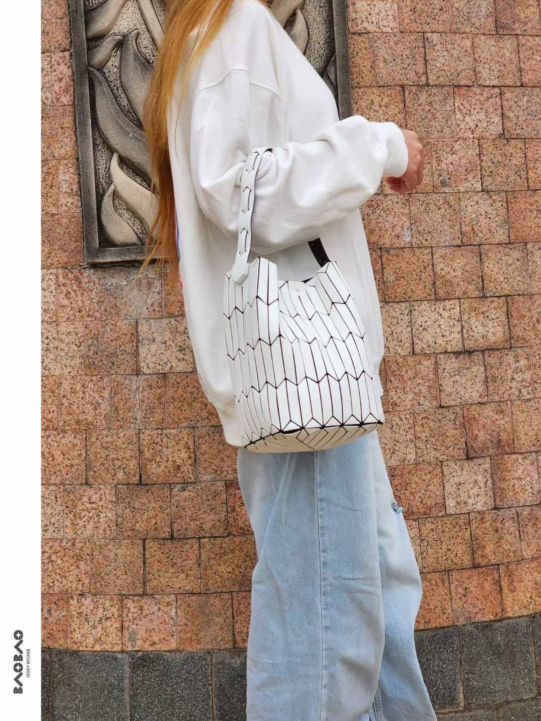 Large : Baobao Issey Miyake Large Bucket กระเป๋าบัคเก็ตขนาดใหญ่สามารถใช้ใส่ร่มพับได้หรือขวดน้ำขนาดเล็กได้ ซีรีย์ใหม่นี้มีจุดเด่นที่แผ่นรูปทรงสี่เหลี่ยมด้านขนานในแนวตั้ง เกิดเป็นรูปทรงสามมิติซึ่งแตกต่างไปจากรูปทรงที่เกิดขึ้นจากแผ่นสามเหลี่ยม หูหิ้วสามารถขย