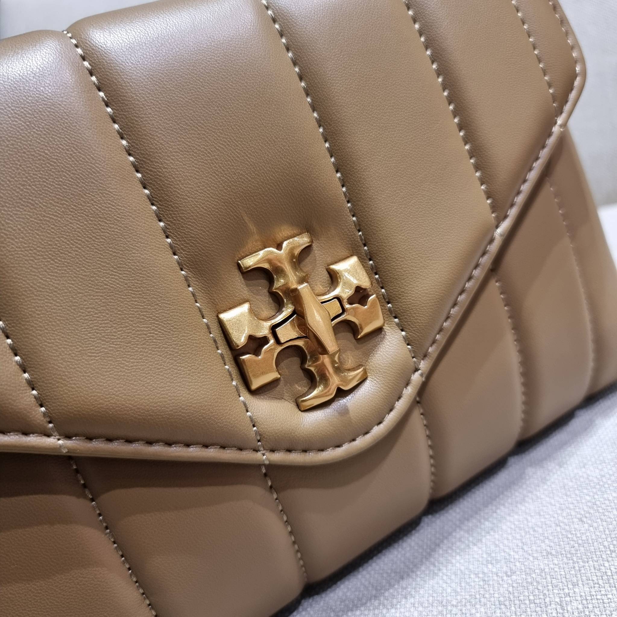 TORY BURCH KIRA QUILTED SMALL SATCHEL มาแล้วด่วนๆ!! กับคอลที่ปังไม่ไหว พร้อมเสิร์ฟสีคลาสสิค กระเป๋าถือ/สะพาย ทรงสวย สะพายคล่องตัว หนังแท้ ดีไซน์บุนวม เส้นคมสวยหรู วัสดุหนังแกะ สัมผัสดีงาม นิ่มมือ เปิด-ปิดด้วยอะไหล่บิดล็อค ภายในเป็นช่องโล่ง มีช่องซิป ใส่ขอ