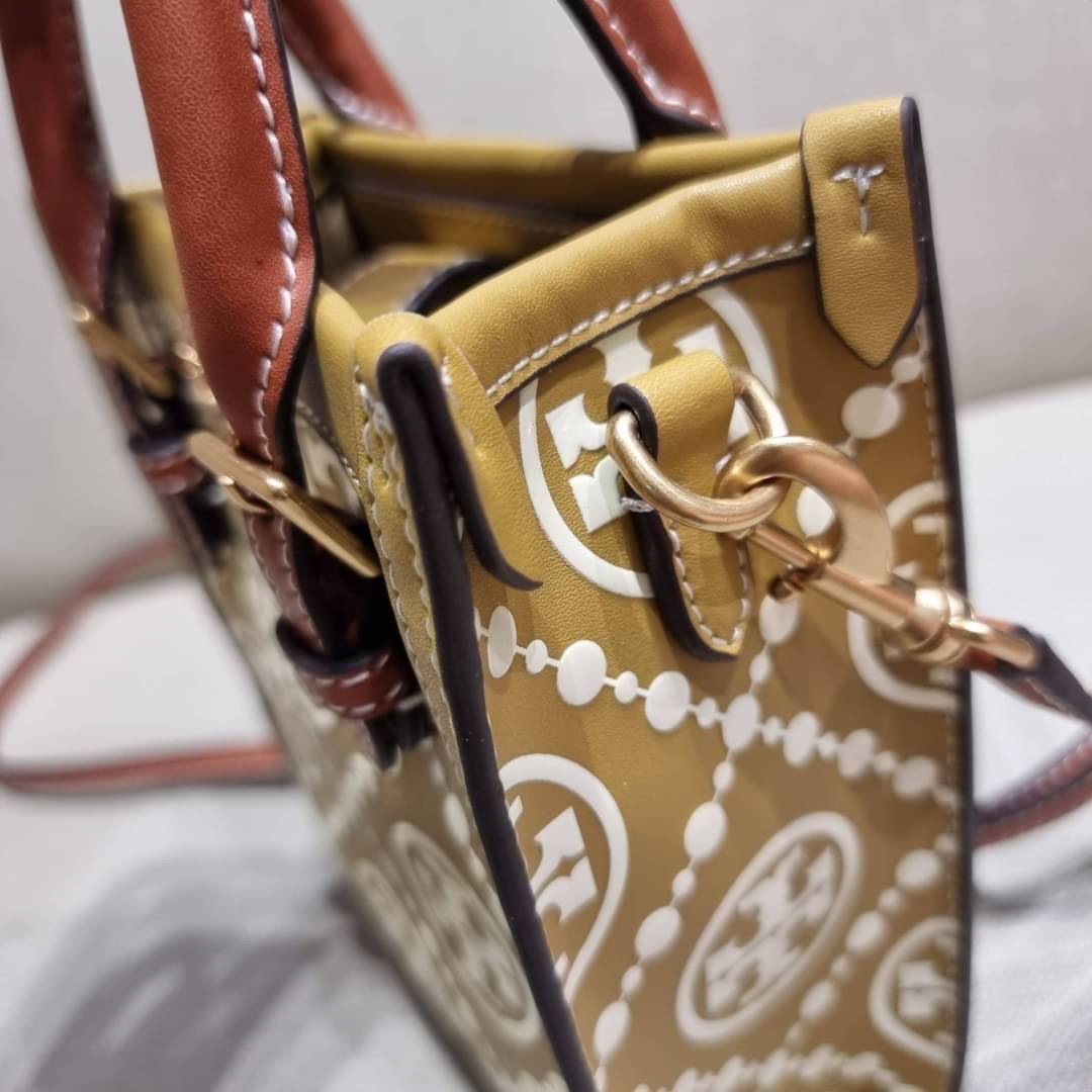 TORY BURCH T MONOGRAM EMBOSSED MINI TOTE สุดหรูกับกระเป๋าสะพายทรงโท้ท ไซส์มินิ ที่สร้างความหรูหราให้ตัวกระเป๋าด้วยดีเทลลายนูน แต่งแต้มลวดลายเอกลักษณ์ สีลูกคุณมากๆ!! วัสดุหนังแท้ ผิวสัมผัสดี ปากกระเป๋ามีแถบแม่เหล็กกันของหล่นได้ ภายในโล่ง ใส่ของจำเป็นได้ โท
