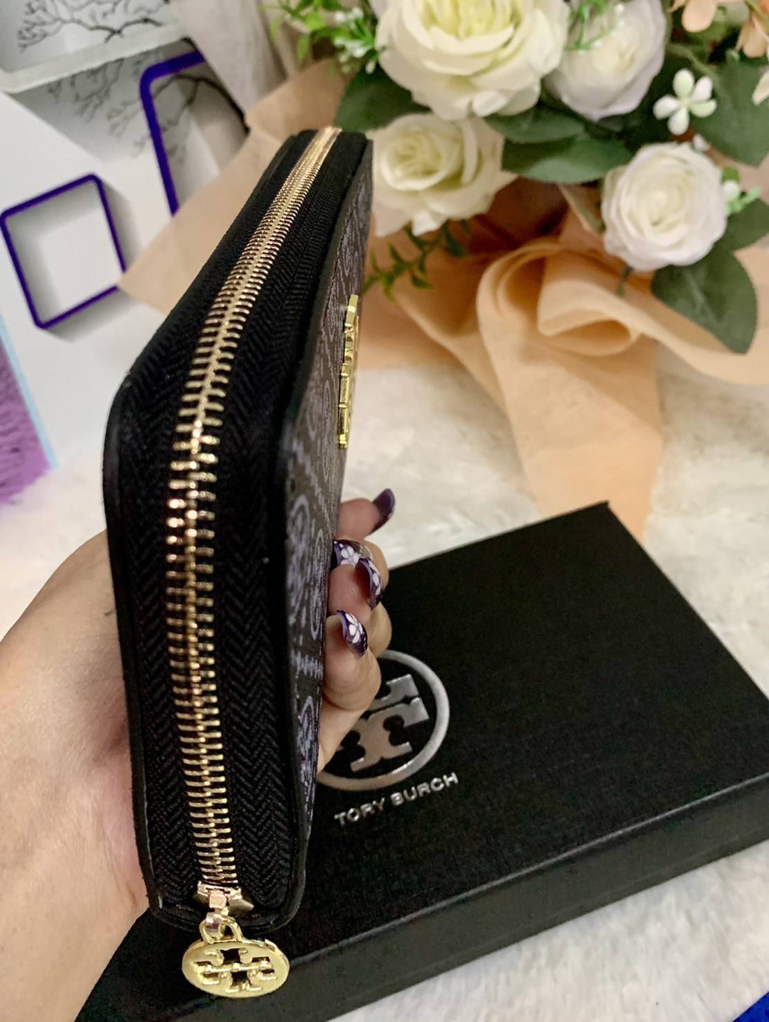 กระเป๋าสตางค์ใบยาว TORY BURCH : Monogram Pattern วัสดุหนังแกะสังเคราะห์ลงเคลือบเพิ่มความเงาอีกชั้น อะไหล่สีทอง **แบบซิปรอบ เปิด - ปิด กระเป๋าด้วยซิปรอบ ด้านในแบ่งออกเป็น 3 Patation ตรงกลางเป็นซิปยาว มีช่องใส่บัตรได้ 8 ใบ หนังเงาสวย จับถนัดมือ พร้อมส่งให้ส