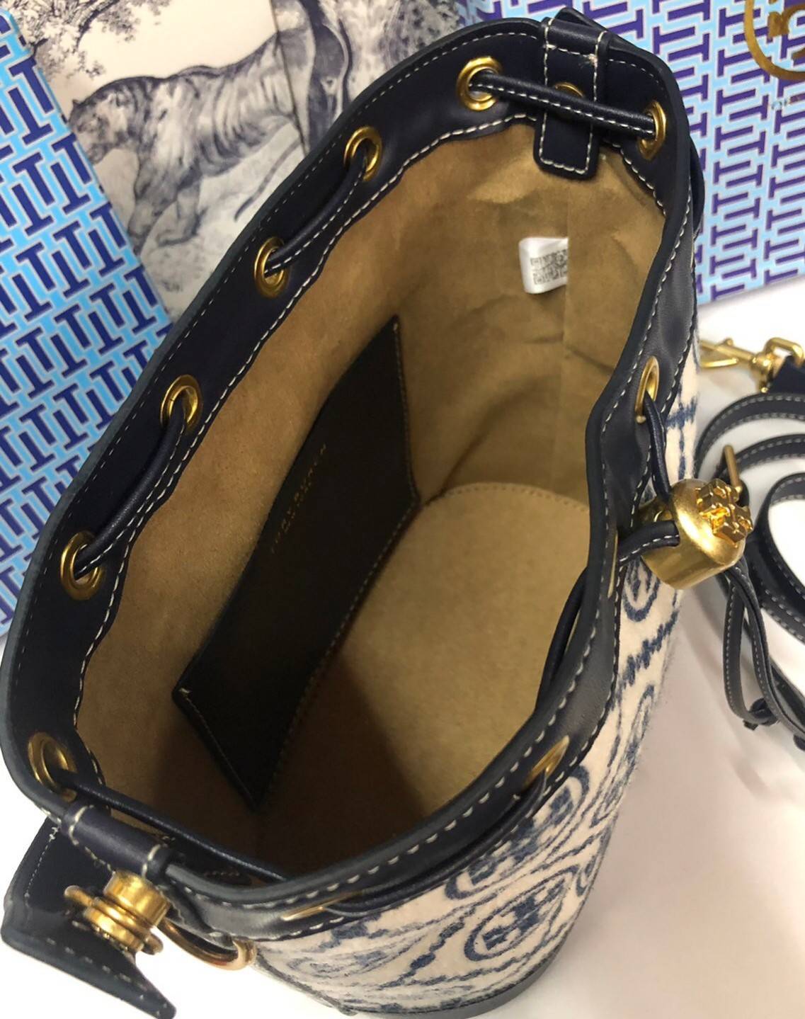 Medium : Tory Burch T Monogram Chenille Bucket Bag เปิดตัวอีกหนึ่งรุ่นกับกระเป๋าลาย T MONOGRAM รุ่นใหม่ล่าสุดจาก TORY BURCH พลาดไม่ได้กับโลโก้สุดคลาสสิก ลวดลาย T Monogram คือวัสดุ chenille หรือที่เรียกว่า ด้านไหมกำมะหยี่ มารังสรรค์ลงบนกระเป๋าBucketใบนี้ เ