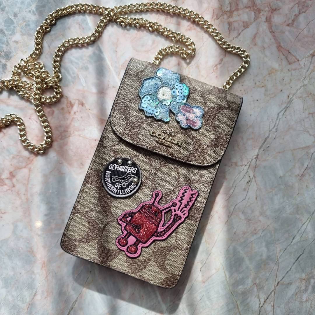 COACH NORTH/SOUTH PHONE CROSSBODY IN SIGNATURE CANVAS F55636 F39955 สุดคลาสสิคกับกระเป๋าสะพายเอนกประสงค์ Case phone ใส่โทรศัพท์มือถือได้ทุกรุ่น ดีไซน์ลายเอกลักษณ์ วัสดุหนังแคนวาสเคลือบลาย ฝาและภายในเป็นหนังสังเคราะห์เรียบ เปิด-ปิดด้วยกระดุม สายสะพายยาวประ