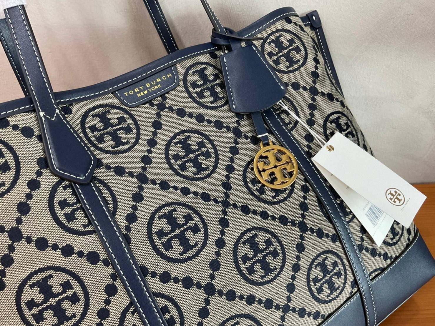 TORY BURCH T MONOGRAM TRIPLE - COMPARTMENT TOTE กระเป๋า/สะพายไหล่ทรง SHOPPING BAG วัสดุผ้าผ้าแคสวาสปักลายสัญลักษณ์แบรนด์ ตั้งอยู่ทรง สวยหรู ดูแพง จุของได้เยอะมาก ภายในแยกเป็น 2 ช่องหลัก 1 ช่องซิปตรงกลาง แบ่งเป็นสัดส่วนใช้งาน
