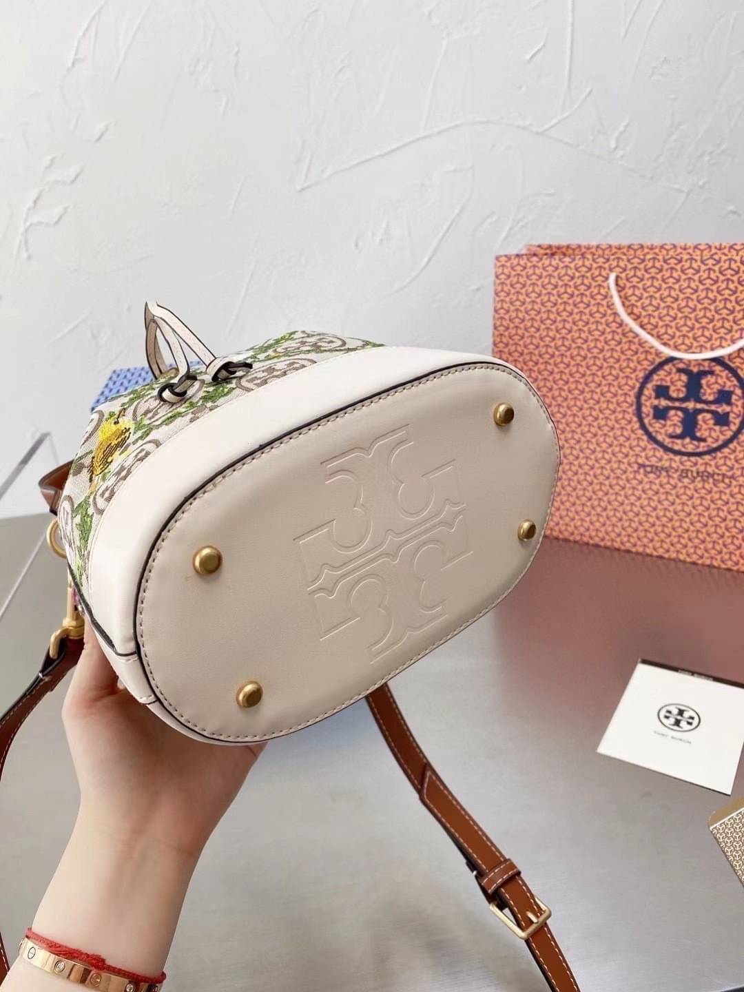 TORY BURCH T MONOGRAM JACQUARD EMBROIDERED BUCKET BAG ครั้งแรกกับโมโนแกรม ที่ได้รับแรงบันดาลใจมาจากโลโก้สุดคลาสสิก กลับมาอีกครั้งในรูปแบบของ ลวดลาย T Monogram ที่ผสมผสานความร่วมสมัยเข้ากับความเป็นเอกลักษณ์ของแบรนด์เข้าไว้ด้วยกัน โดยเป็นการนำเอาลวดลาย T Mo