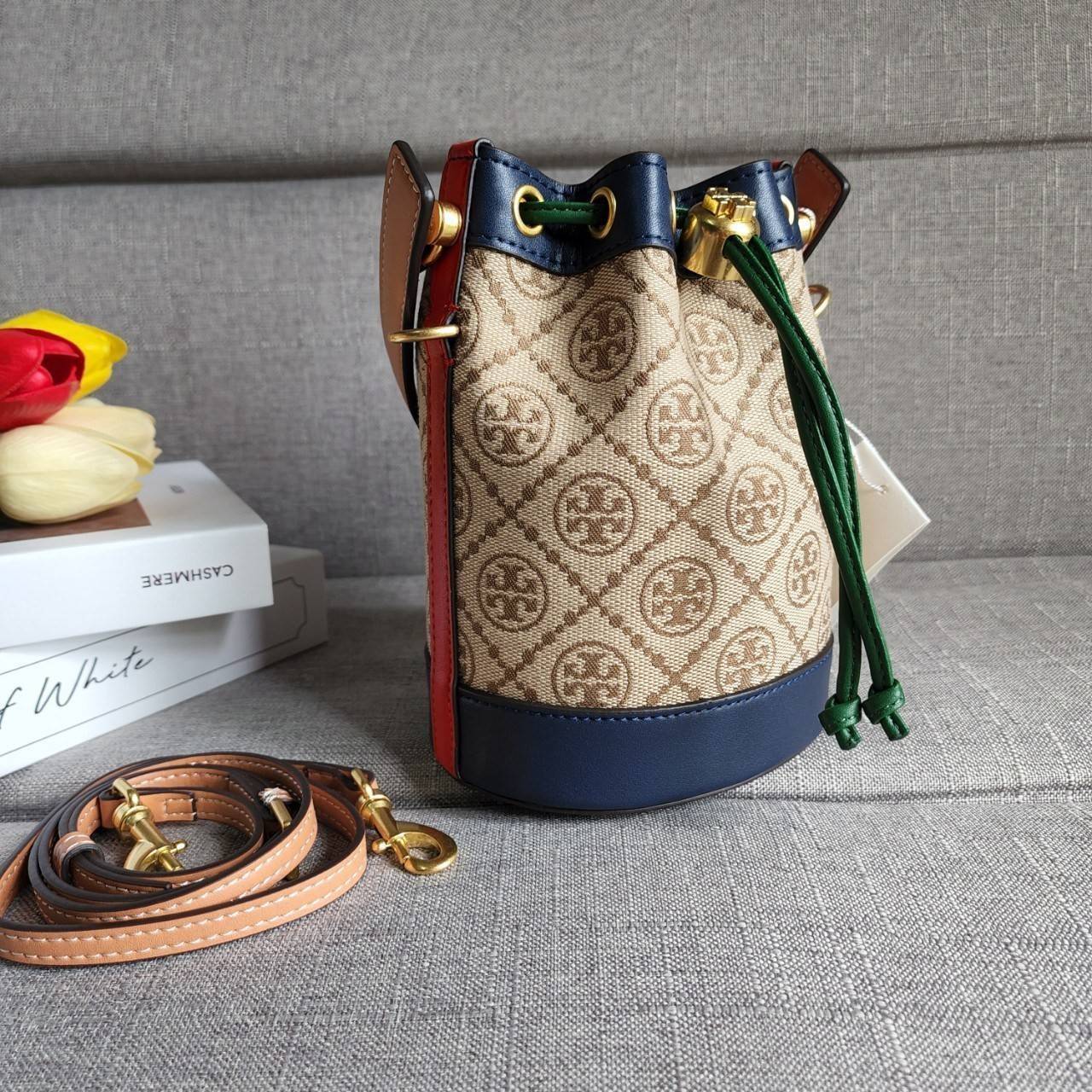 TORY BURCH T MONOGRAM COLORBlOCK JACQUARD MINI BUCKET BAG คอลเลคชั่นใหม่ล่าสุด ครอบครองก่อนใคร รุ่นบัคเก็ตทรงจีบ วัสดุ jacquard สลับหนังแท้ ตัดขอบข้างสีแดงทำให้ดูโดดเด่น หูจับหนังแท้ เปิด ปิด แบบหูรูด ภายในช่องโล่งกว้าง มาพร้อมสายสะพายข้างหนังแท้ ปรับระดั