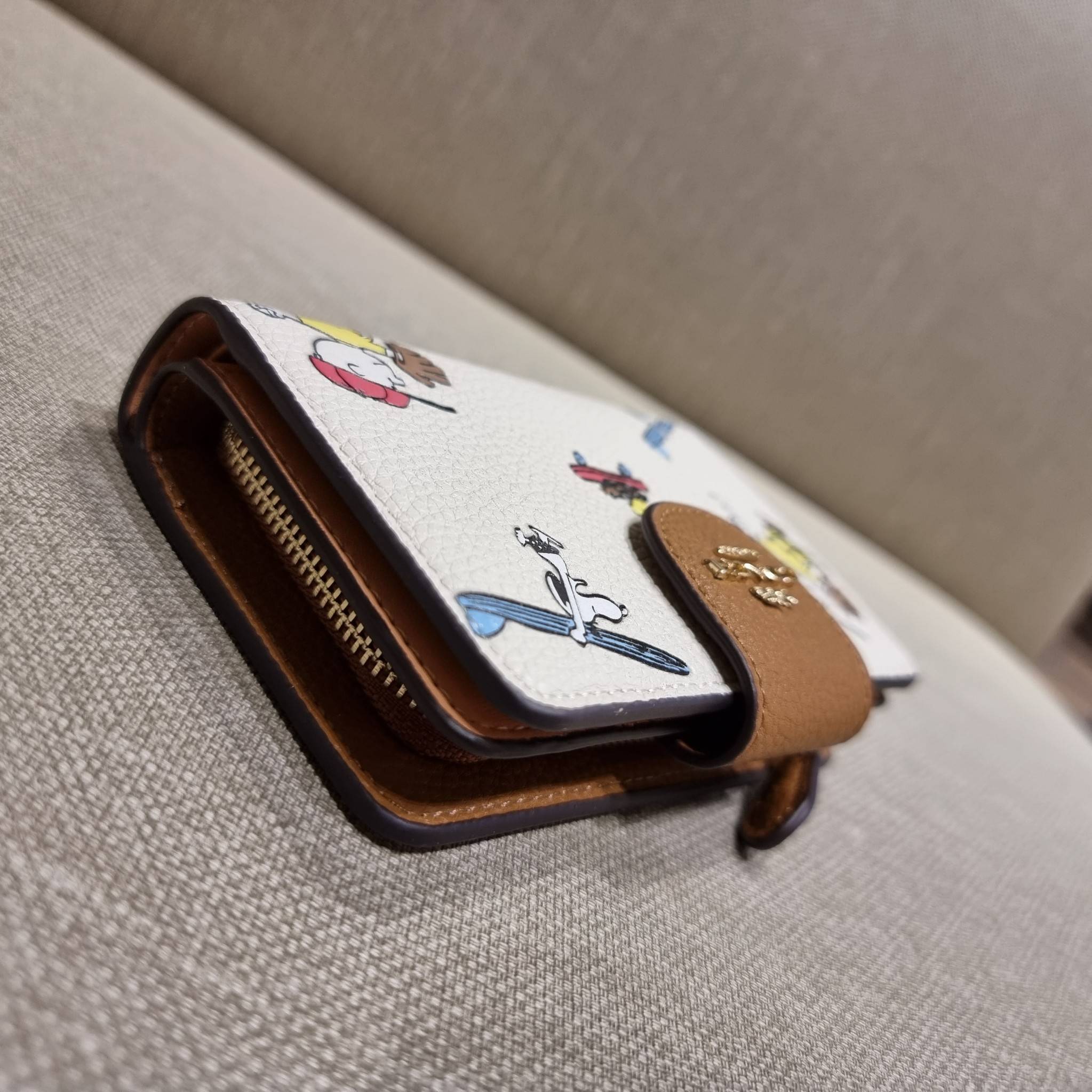 COACH C4899 MEDIUM CORNER ZIP WALLET WITH SNOPPY PRINT น้องใหม่คอลเลคชั่นสุดชิค ดีไซน์ลายพริ้นท์ผองเพื่อนสนูปพี น่ารักน่าใช้ เพิ่มลูกเล่นให้กระเป๋าสตางค์ของคุณไปอีก กับกระเป๋าสตางค์ใบกลาง ขนาดกำลังเหมาะมือ วัสดุหนัง pepble ทนทาน มีช่องใส่บัตรและธนบัตรครบ 