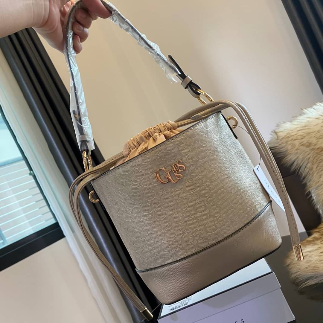 Guess Agata Bucket Handbag กระเป๋ารุ่นใหม่ล่าสุดทรงถังสุดน่ารัก พิมพ์ลายรอบใบ วัสดุ Saffiano PU คุณภาพดี นิ่ม น้ำหนักเบา ด้านหน้าประดับด้วยโลโก้แบรนด์สวยโดดเด่น เปิด-ปิดด้วยเชือกหนังใช้หูรูดปลายเชือกประดับอะไหล่ทองสะดวกใช้ ด้านในโล่งกว้างมีช่องเล็กสำหรับใ