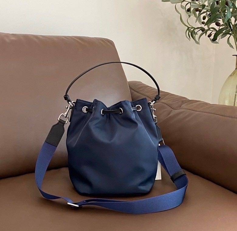 Tory Burch Virginia Nylon Bucket Bag / Tory Burch logo-plaque bucket bag กระเป๋าสะพายทรงบัคเก็ต เปิด-ปิดหนังรูดปากกระเป๋า มีหูหิ้วในตัว คล้องแขนเก๋ๆ ภายในเป็นช่องโล่ง มีช่องย่อย ใส่ของสำคัญจุกจิกได้ มีสายครอส จะสะพายไปไหนก็ได้ทุกโอกาส สวยเลิศทุกสี พร้อมส่