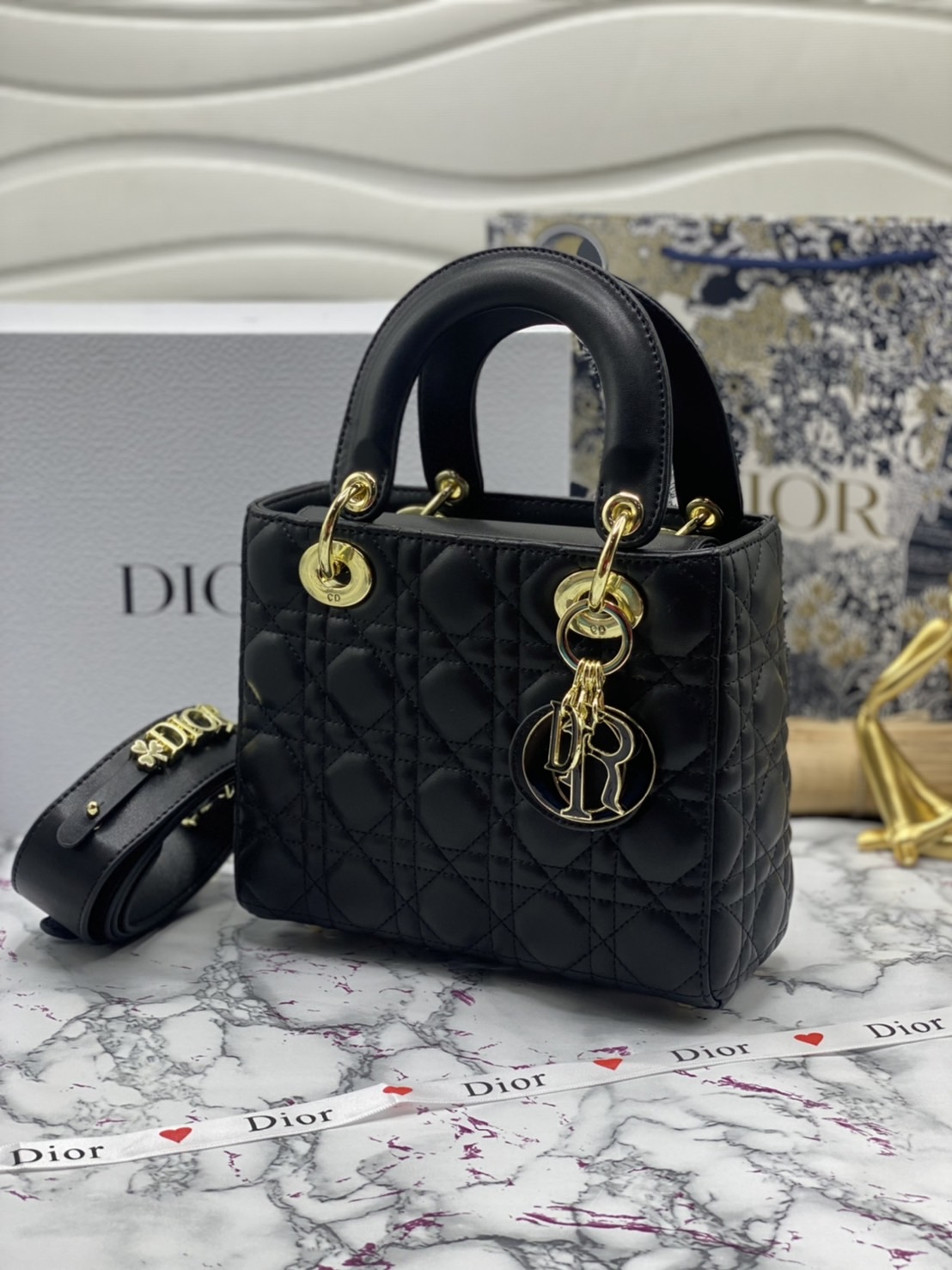 หนังแท้ DIOR LADY BAG 20cm ความสง่างามอีกหนึ่งรุ่นของ Dior รูปทรงสีเหลียม ขนาดกระทัดรัด ตั้งอยู่ทรง ฐานกระเป๋าแข็งแรง มีหมุดรองฐาน ดีไซน์ที่มีเอกลักษณ์เฉพาะตัว ด้านหน้าตกแต่งด้วยตัวอักษร D.I.R ห้อยเป็นพวงกุญแจ จะถือด้วยมือหรือสะพายไหล่ก็ดูดีมากๆ ค่ะ