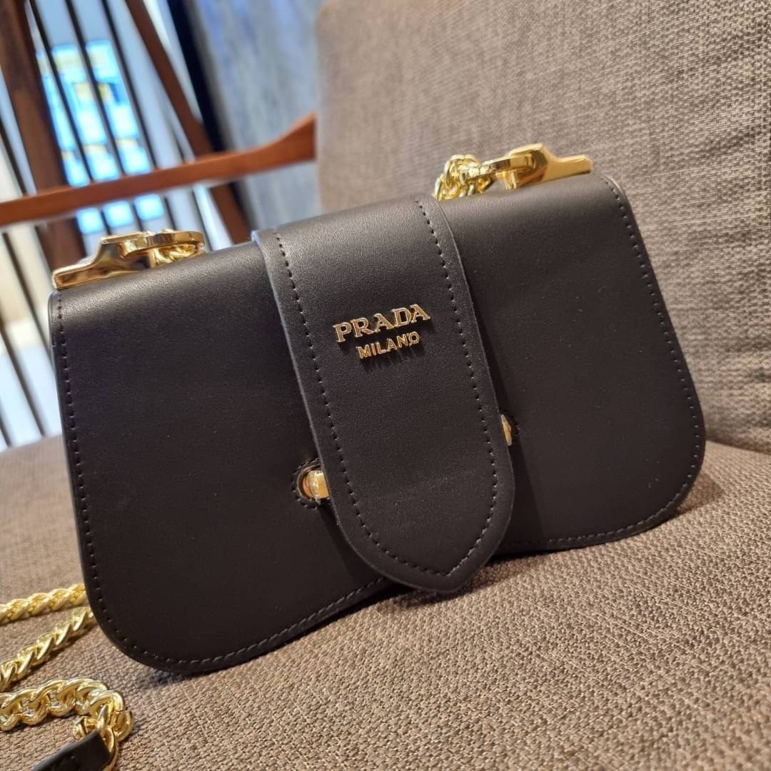 PRADA FRAGRANCE SHOULDER BAG WITH GWP ไอเท็มสุดโปรดที่ควรค่าแก่การครอบครองและเก็บสะสม กระเป๋าสะพายไหล่ สวยคม สีดำคลาสสิคตัดกับอะไหล่ทองเป็นอย่างดี วัสดุหนังแท้เต็มใบ เปิดปิดด้วยแถบหนังสอดในช่อง ใช้งานสะดวก พกพาง่าย ขนาดกำลังสวย สายสะพายในตัว สะพายได้หลากห