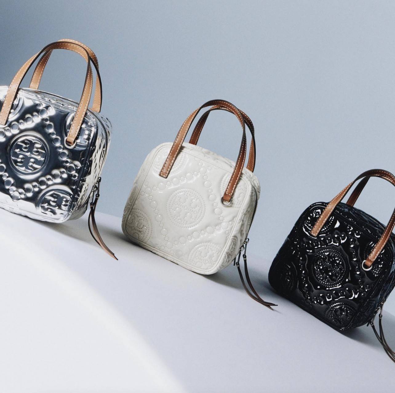 Tory Burch T Monogram Embroidered Patent Cube คอลเลคชั่นใหม่ รุ่นลิมิเต็ดรูปทรงใหม่ T Monogram สุดcube วัสดุหนังแท้ เปิด-ปิดด้วยซิป ภายในกว้าง มีช่องแยก 1 ช่อง สามารถใส่โทรศัพท์มือถือได้ทุกรุ่น สามารถถือหิ้วหรือสะพายได้ สายสามารถถอดและปรับระดับได้คะ