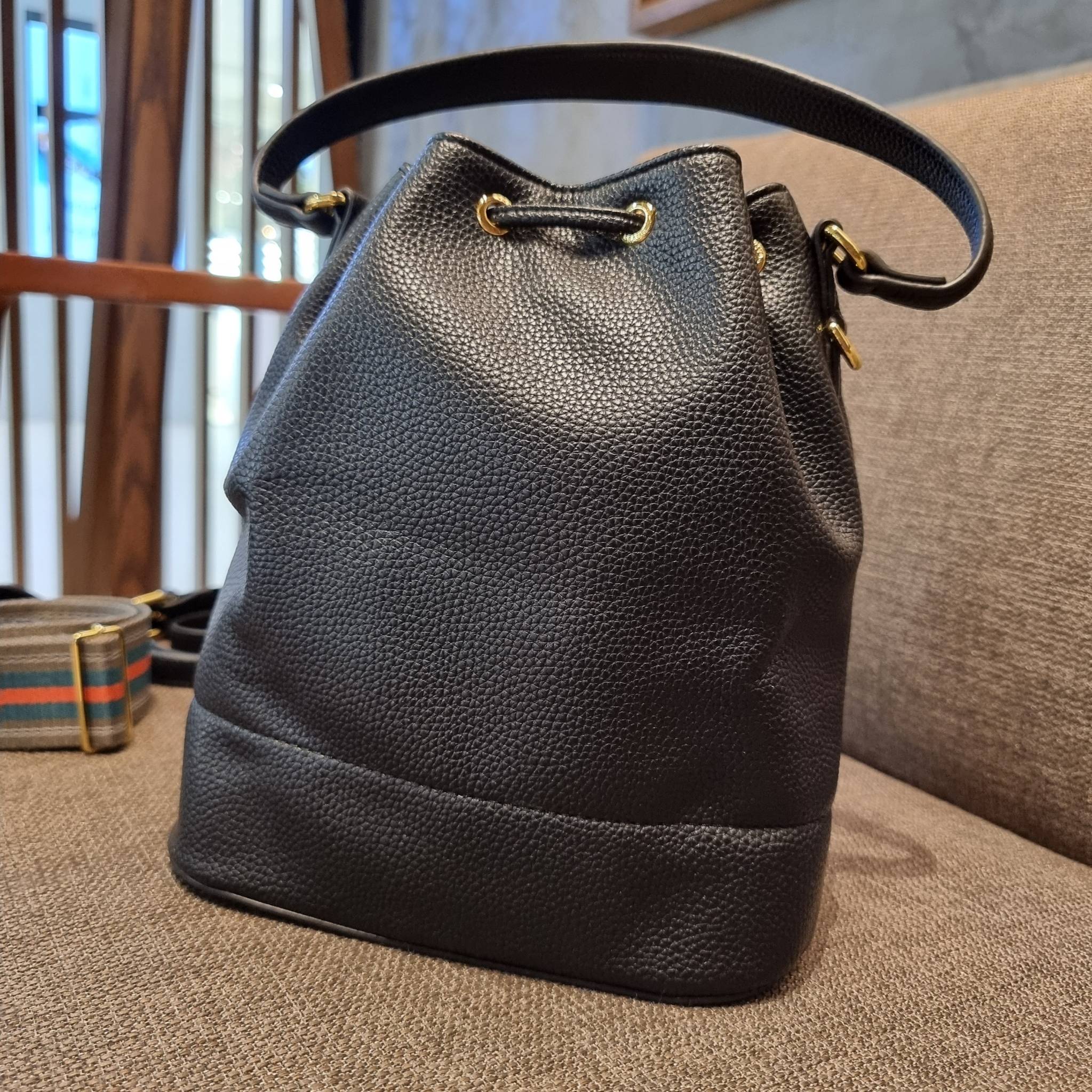Prada leather bucket bag กระเป๋าสะพายทรงขนมจีบ ดีไซน์เรียบ แต่หรู น่าใช้มากๆ หนังสวยมาก วัสดุหนัง pepble สัมผัสนิ่มมือ ตกแต่งโลโก้สีทองตัดหนังดำ คือเลิศ!! ปากกระเป๋ารูดเปิดปิดได้ สะดวกใช้งาน ภายในโล่งกว้าง จุของได้เยอะ ไม่ธรรมดาเลย พิเศษ!! นอกจากสายคล้องใ