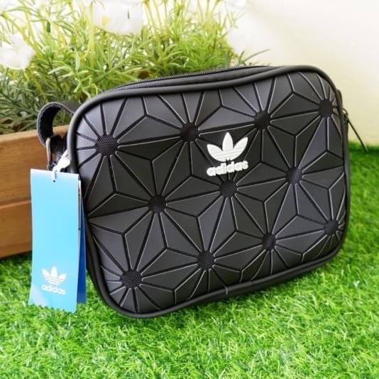 adidas mini airline bag *outlet* กระเป๋าสะพายข้างทรงสปอร์ต ด้านหน้าติดโลโก้แบรนด์ ดีไซน์ลาย 3D ด้านหลังเป็นหนังเรียบ มีช่องซิปสามารถใส่สิ่งของได้ รุ่นนี้เปิดปิดด้วยซิปคู่ ซิปปั๊มแบรนด์ทุกจุด ด้านในเป็นช่องกว้าง มีช่องซิป สายสะพายยาวสามารถปรับระดับได้ สาวก