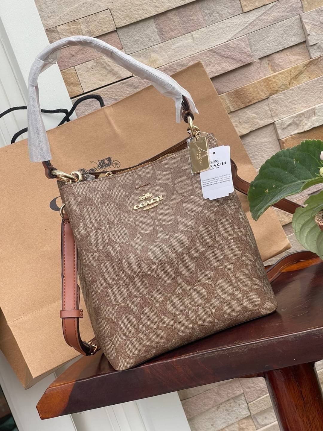 COACH SMALL TOWN BUCKET BAG IN SIGNATURE สำหรับสาวแฟชั่นที่ชอบรายละเอียดชิคๆ ดีไซน์สุดเก๋ แนะนำเลยสำหรับกระเป๋าทรงบักเก็ตใบนี้ เชื่อว่าสาว ๆ หลายคนชื่นชอบ เป็นไอเทมที่สามารถแมทช์ได้กับเสื้อหลากหลายสไตล์ บรรจุของได้เยอะโดยที่กระเป๋าไม่เสียทรง แบ่งช่องใช้งา