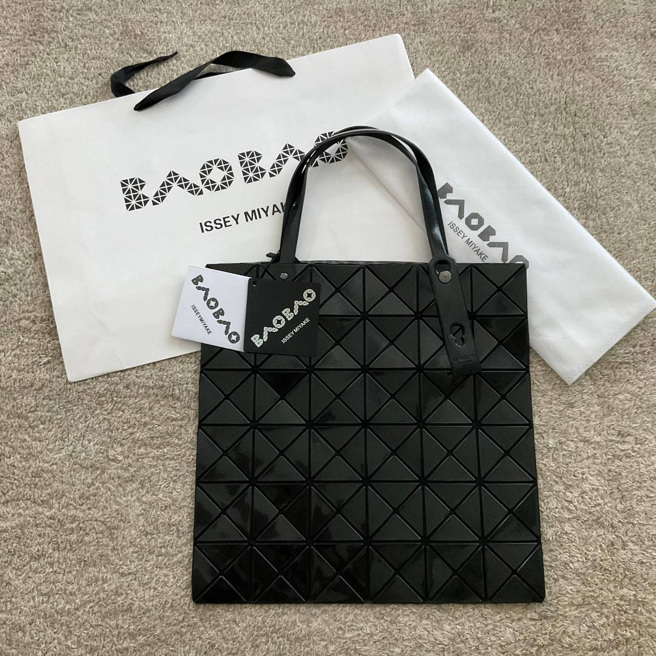 BAO BAO ISSEY MIYAKE TOTE BAG (6x6) กระเป๋าสะพายไหล่ ใบใหญ่ ทรงโท้ท จุดเด่นคือ ปรับได้หลายทรงตามเอกลักษณ์เฉพาะของแบรนด์นี้ ด้านในใส่ของได้เยอะมาก ใส่ไอแพด สมุดโน้ตได้สบายเลย พร้อมช่องซิปใส่ของให้อีกหนึ่งช่อง วัยทำงานหรือวัยนักศึกษา อย่างน้อยต้องมีแบรนด์นี