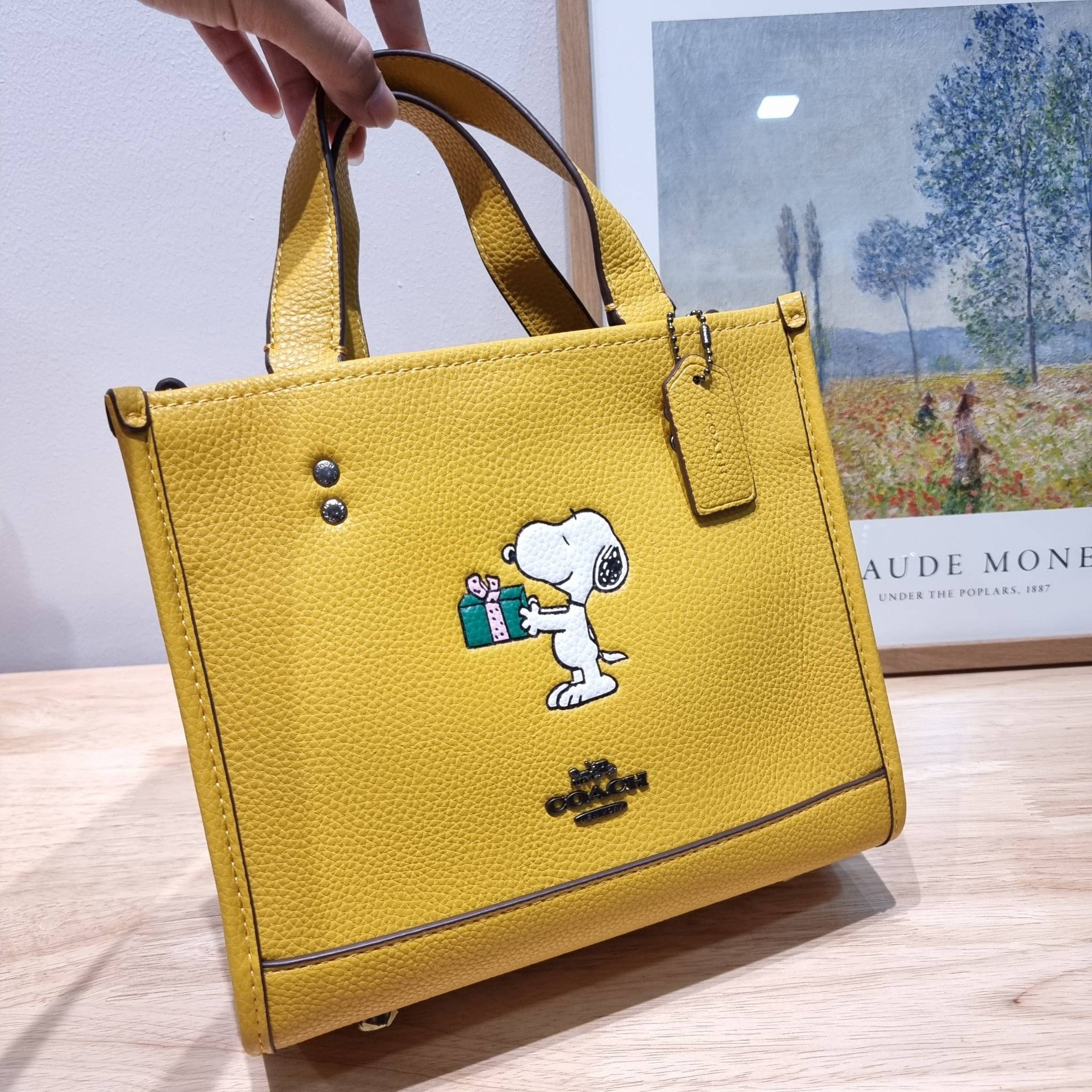 coach x peanuts dempsey tote 22 with snoopy present motif CE918 คอลเลคชั่นใหม่ น้องน่ารักเกินต้านไปมาก!! กับกระเป๋าทรงโท้ท ไซส์กำลังสวย ดีไซน์ ลายการ์ตูนยอดฮิต ที่ใครๆก็ต้องรู้จัก พิมพ์คมชัดลงบนหนัง pepble ผิวสัมน่าใช้ ปากกระเป๋ามีกระดุมแม่เหล็กปิดกันของห
