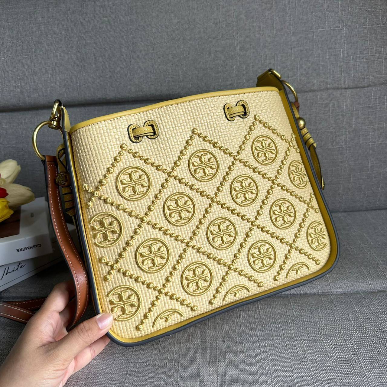 TORY BURCH T Monogram Straw Bell Bag กระเป๋าสะพายข้างรุ่นคลาสสิกที่ได้แรงบันดาลใจจากการควิลท์แบบดั้งเดิมของเพนซิลเวเนีย คอลเลกชันบ่งบอกถึงความมีสไตล์เหนือกาลเวลา รูปทรงเรียวโดดเด่น ปักทอลายแบรนด์อย่างสวยงาม เปิด ปิดด้วยเชือกรูด ด้านในช่องโล่งกว้าง ซับในผ้