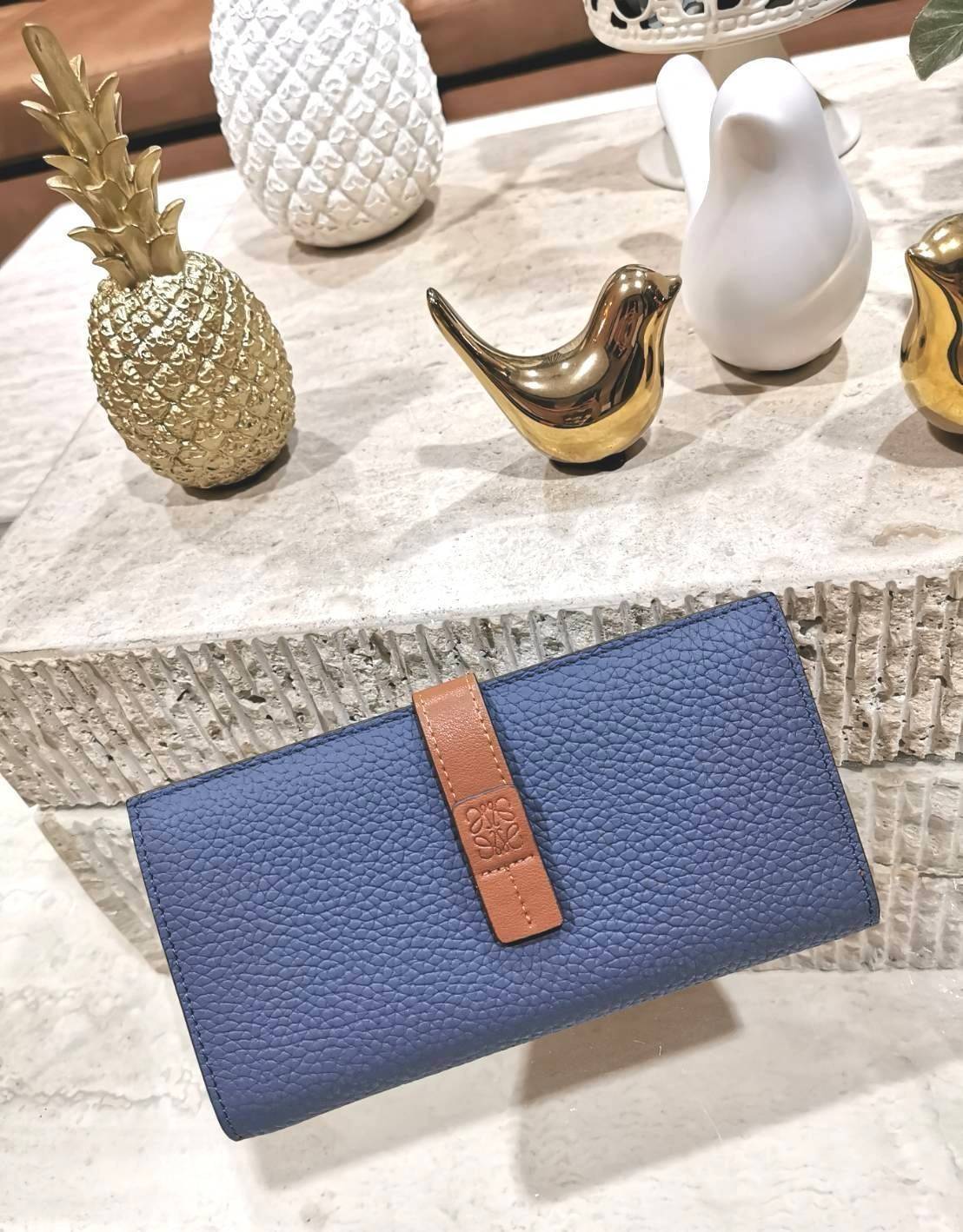 LOEWE LONG WALLET BAG วัสดุหนังแท้เทคเจอร์สวยอยู่ทรงปั้มโลโก้แบรนด์ด้านหน้าเปิดปิดด้วยกระดุม ภายในมีช่องใส่ธนบัตรหลายช่อง ช่องหลักสามารถใส่มือถือได้ มีช่องซิปใส่เหรียญ ช่องใส่ธนบัตรใส่แบงก์พันได้ สวยน่าใช้ พร้อมส่งที่ไทยสุดคุ้มห้ามพลาด!