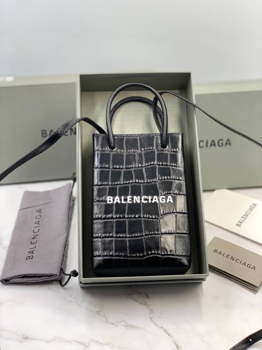 หนังแท้ BALENCIAGA Shopping Phone Pouch leather tote พกกระเป๋าช้อปปิ้งขนาดมินิ ไปทุกที่ในฤดูกาลนี้ ดีไซน์ที่ใช้ได้ทุกวันตั้งแต่หนังแบบมีเท็กซ์เจอร์ ภาพสินค้าถ่ายจากงานขายจริง ใช้งานต่างประเทศได้