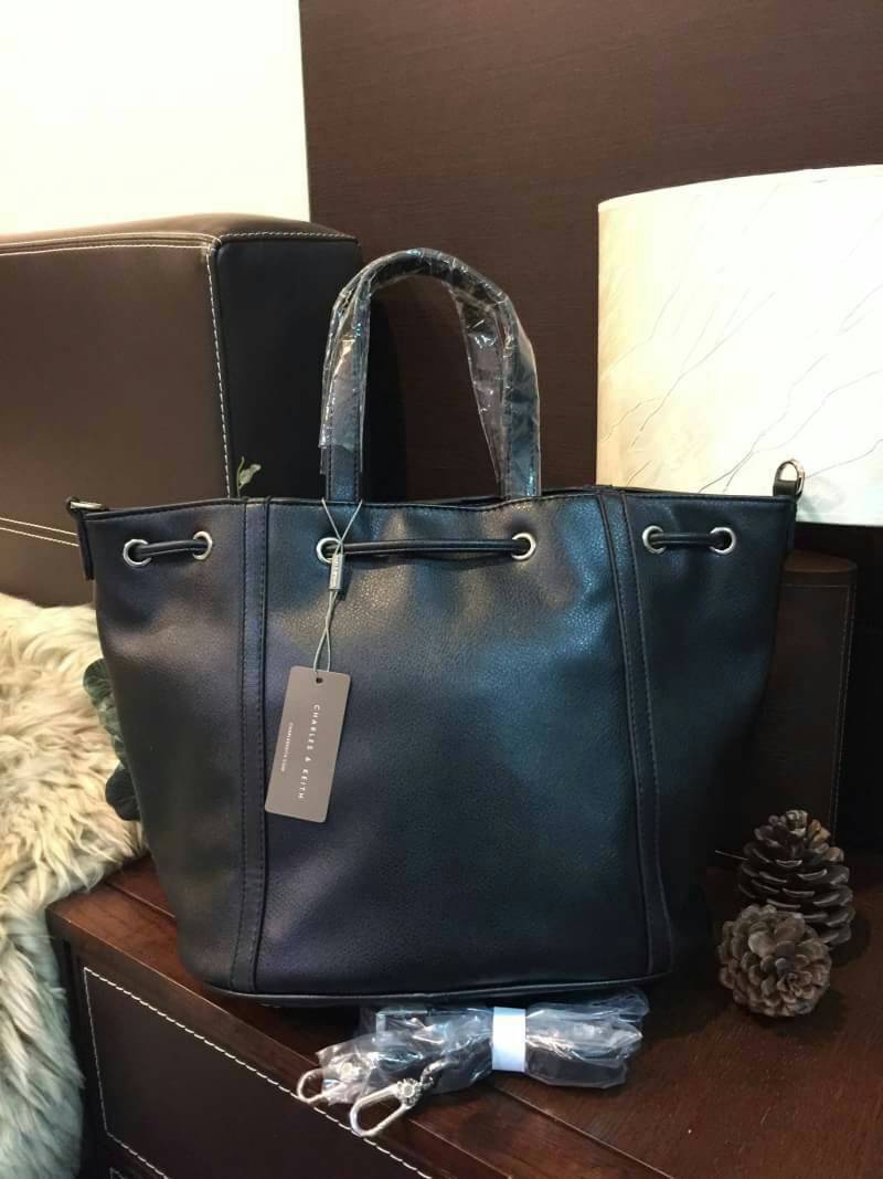 CHARLES & KEITH TASSEL DRAWSTRING BAG กระเป๋าถือหรือสะพายหนังนิ่มสวย น้ำหนักเบา ดีไซน์โดดเด่น ที่หูรูด Drawstring ประดับพู่ สามารถถือหรือสะพายได้ 2 ทรง ไม่จำเจ ปั๊มโลโก้ด้านหน้า ภายในมีช่องซิปเเละช่องเล็กใส่ของ ฐานเสริมอย่างดีใส่ ipad / iphone ของใช้ได้จุ