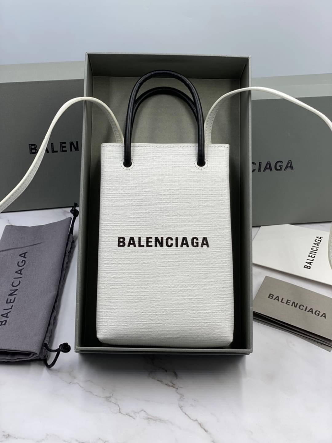 หนังแท้ BALENCIAGA Shopping Phone Pouch leather tote พกกระเป๋าช้อปปิ้งขนาดมินิ ไปทุกที่ในฤดูกาลนี้ ดีไซน์ที่ใช้ได้ทุกวันตั้งแต่หนังแบบมีเท็กซ์เจอร์ ภาพสินค้าถ่ายจากงานขายจริง ใช้งานต่างประเทศได้