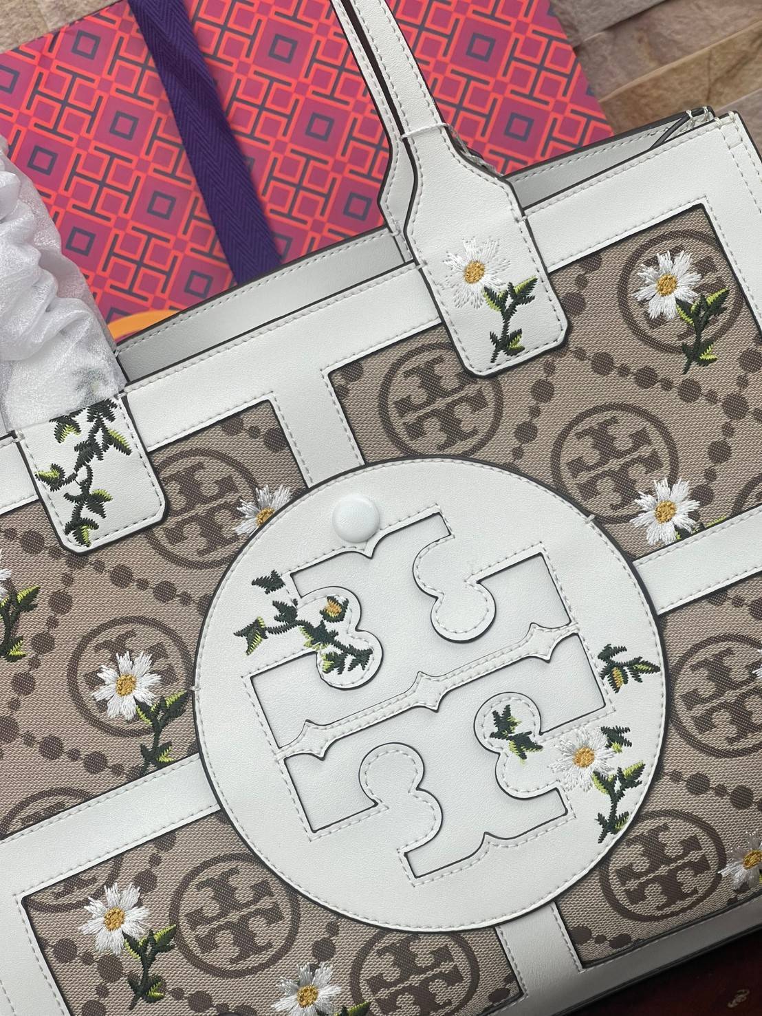 Tory burch ella jacquard embroidered quadrant tote ลายโมโนแกรม (Monogram) สัญลักษณ์สุดโดดเด่นที่คิดค้นขึ้นมาเพื่อให้แบรนด์มีเอกลักษณ์ สำหรับรุ่นนี้เป็นกระเป๋าที่ใส่ของได้เยอะ สามารถใส่สิ่งของที่จำเป็นสำหรับการทำงานได้ ง่ายต่อการถือและการหยิบใช้ข้าวของในกร