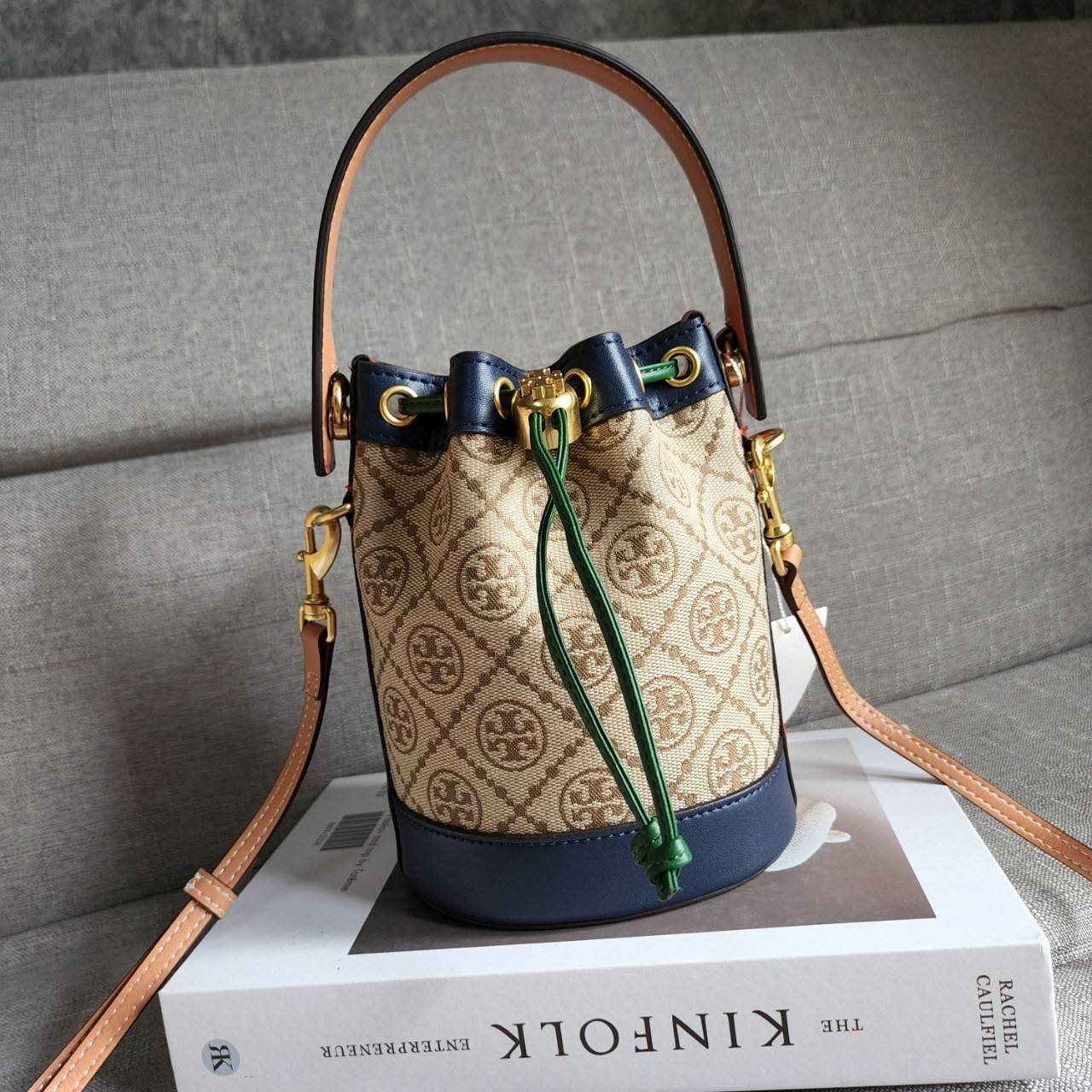 TORY BURCH T MONOGRAM COLORBlOCK JACQUARD MINI BUCKET BAG คอลเลคชั่นใหม่ล่าสุด ครอบครองก่อนใคร รุ่นบัคเก็ตทรงจีบ วัสดุ jacquard สลับหนังแท้ ตัดขอบข้างสีแดงทำให้ดูโดดเด่น หูจับหนังแท้ เปิด ปิด แบบหูรูด ภายในช่องโล่งกว้าง มาพร้อมสายสะพายข้างหนังแท้ ปรับระดั