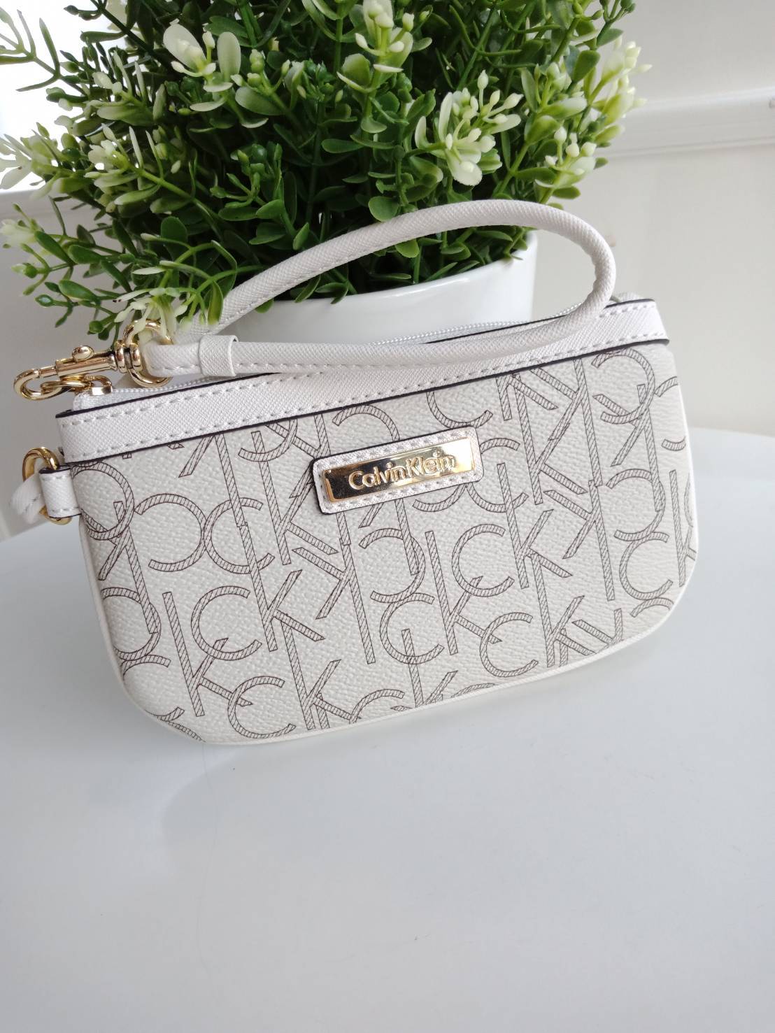 New must have item! กระเป๋าคล้องมือ ทรงน่ารัก จากแบรนด์ calvin klein มีมาให้ช้อปคะ หนัง pvc ทั้งใบอย่างดี มีสายคล้องมือเก๋ ด้านหน้าตกแต่งด้วยโลหะปั้มแบรนด์ เปิดปิดด้วยซิป ด้านในบุด้วยผ้าปั้มแบรนด์ มีช่องใส่บัตรแยก จะใส่ธนบัตรหรือบัตร ก็พกติดตัวในวันสบายๆ